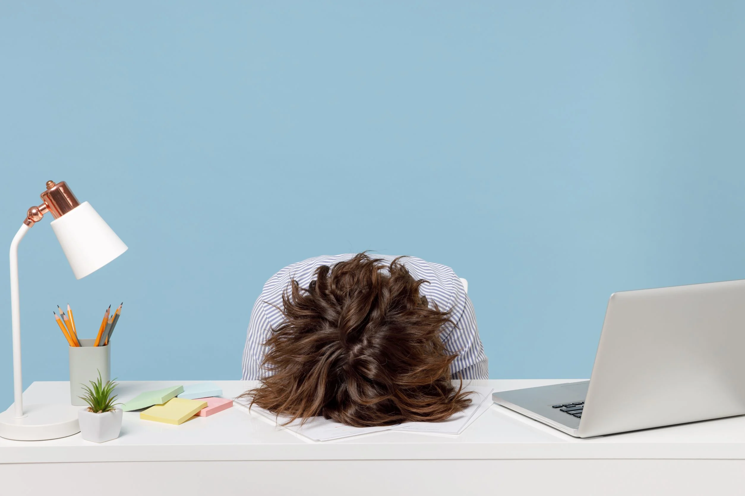 A woman with her head on a desk