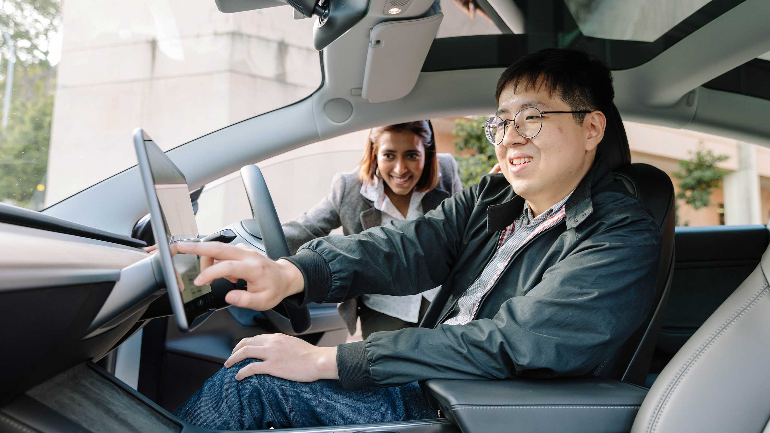 An image Dr Kai Li Lim and Dr Dia Adhikari Smith, from UQ E-Mobility Team checking out the features of a Tesla.