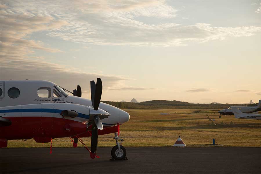 An image of a Royal Flying Doctor Service B360 aircraft takes off from the Caloundra Aerodrome runway.