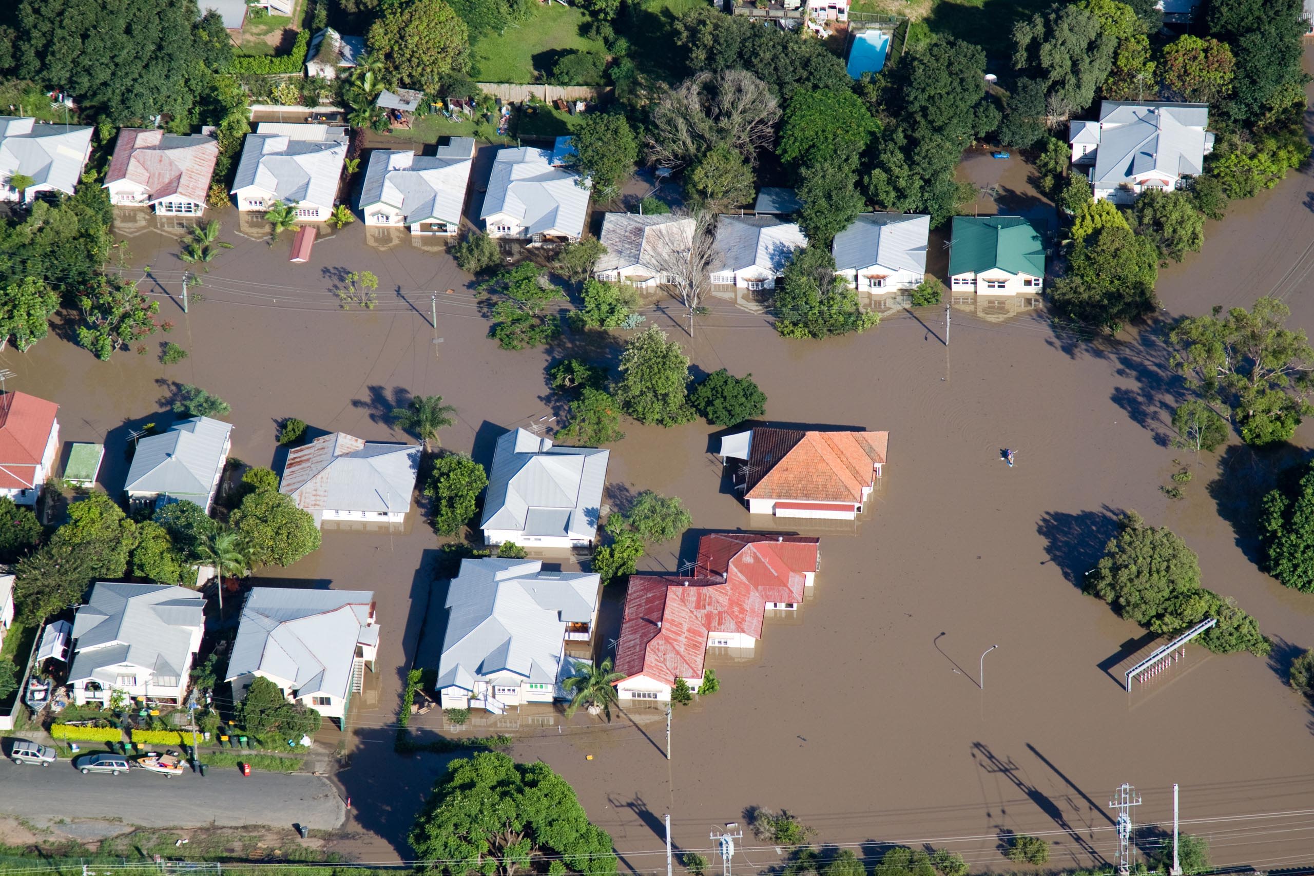 An aerial view of a suburb showing houses flooded up to window height