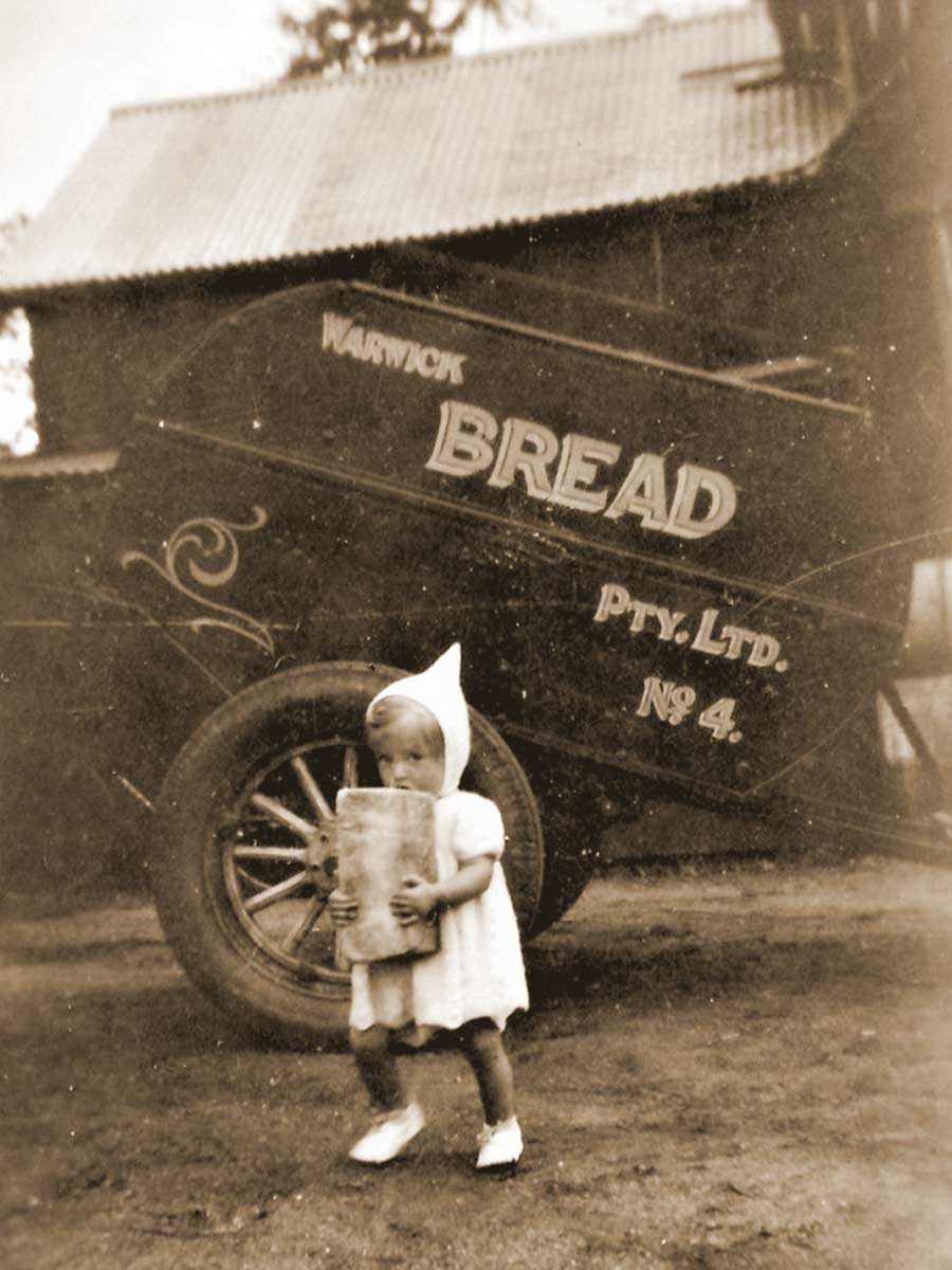 An image of Judith Anderson as young child carrying a loaf of bread in front of her family's bakery wagon in Warwick.