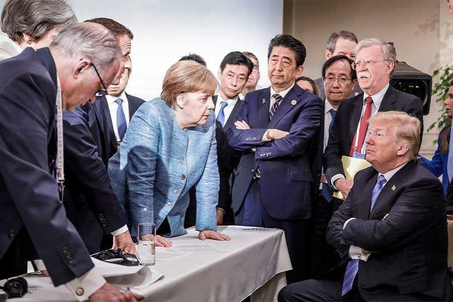 German Chancellor Angela Merkel deliberates with US president Donald Trump during the second day of the G7 summit on June 9, 2018.