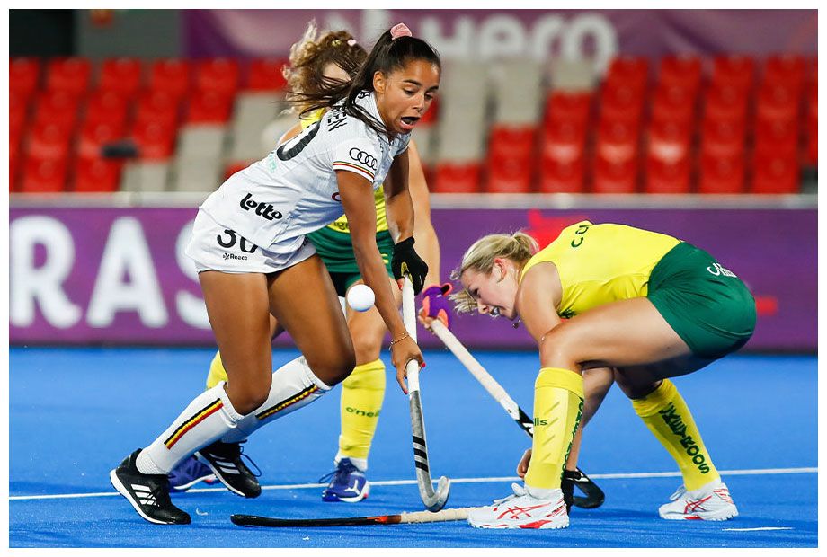 An image of Claire Colwill going head-to-head with Belgium's Ambre Ballenghien during the FIH Hockey Women's World Cup.
