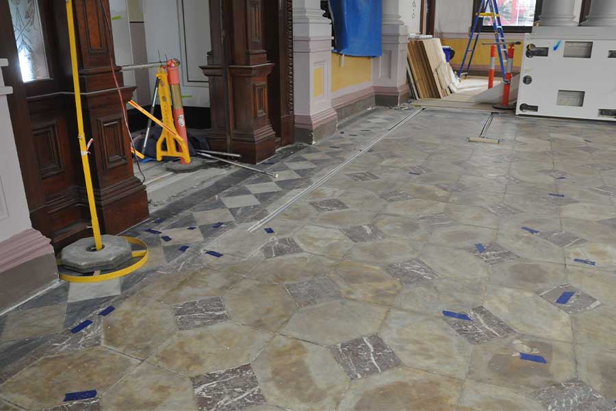 An image of the marble floor being worked restored. Image: Conrad Gargett
