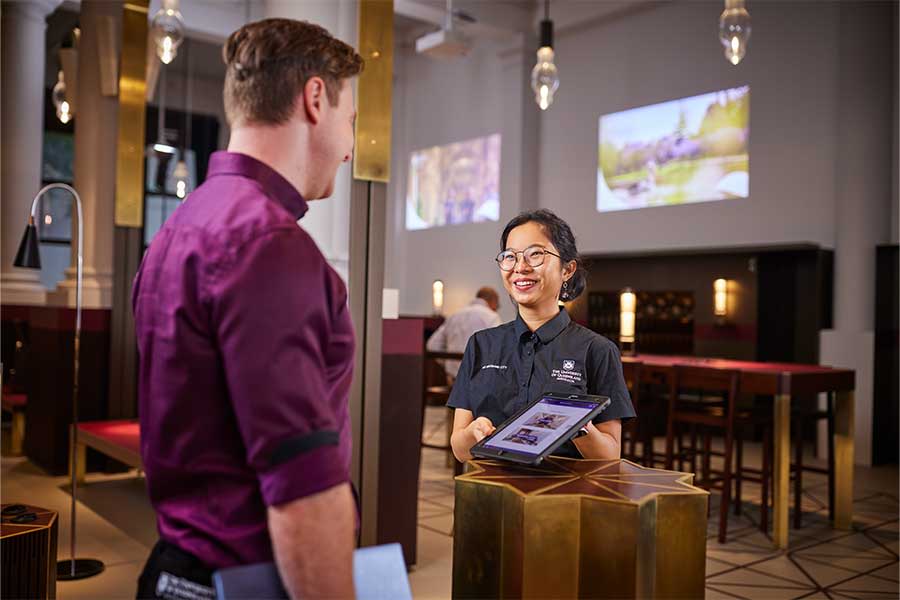 An image of a concierge checking in a male guest at The Atrium.