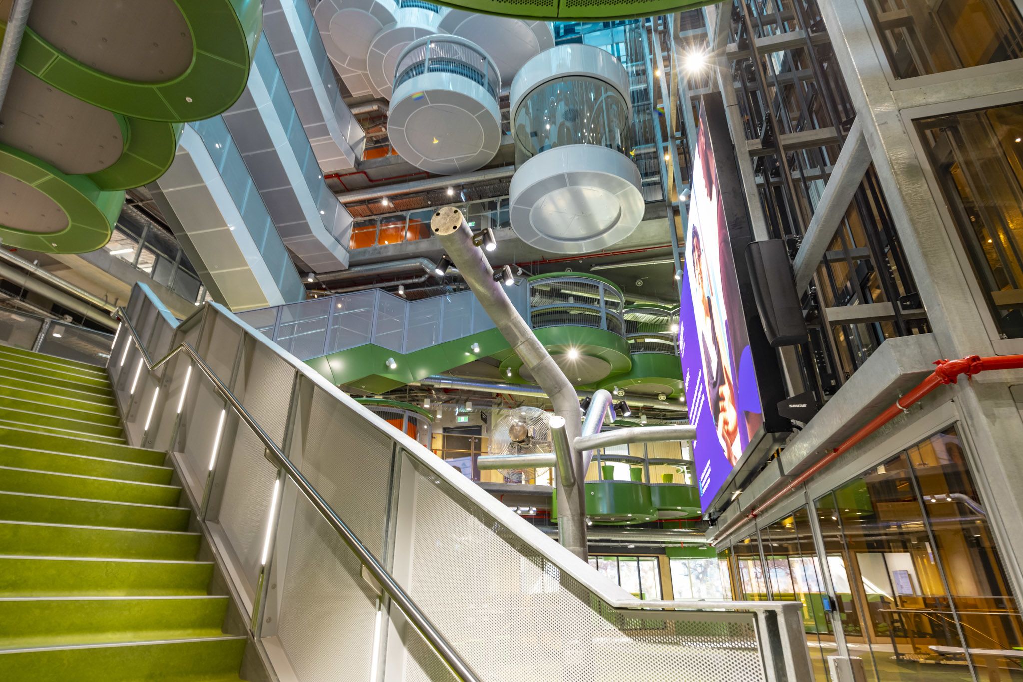 An interior view of the building, featuring a staircase and breakout pods