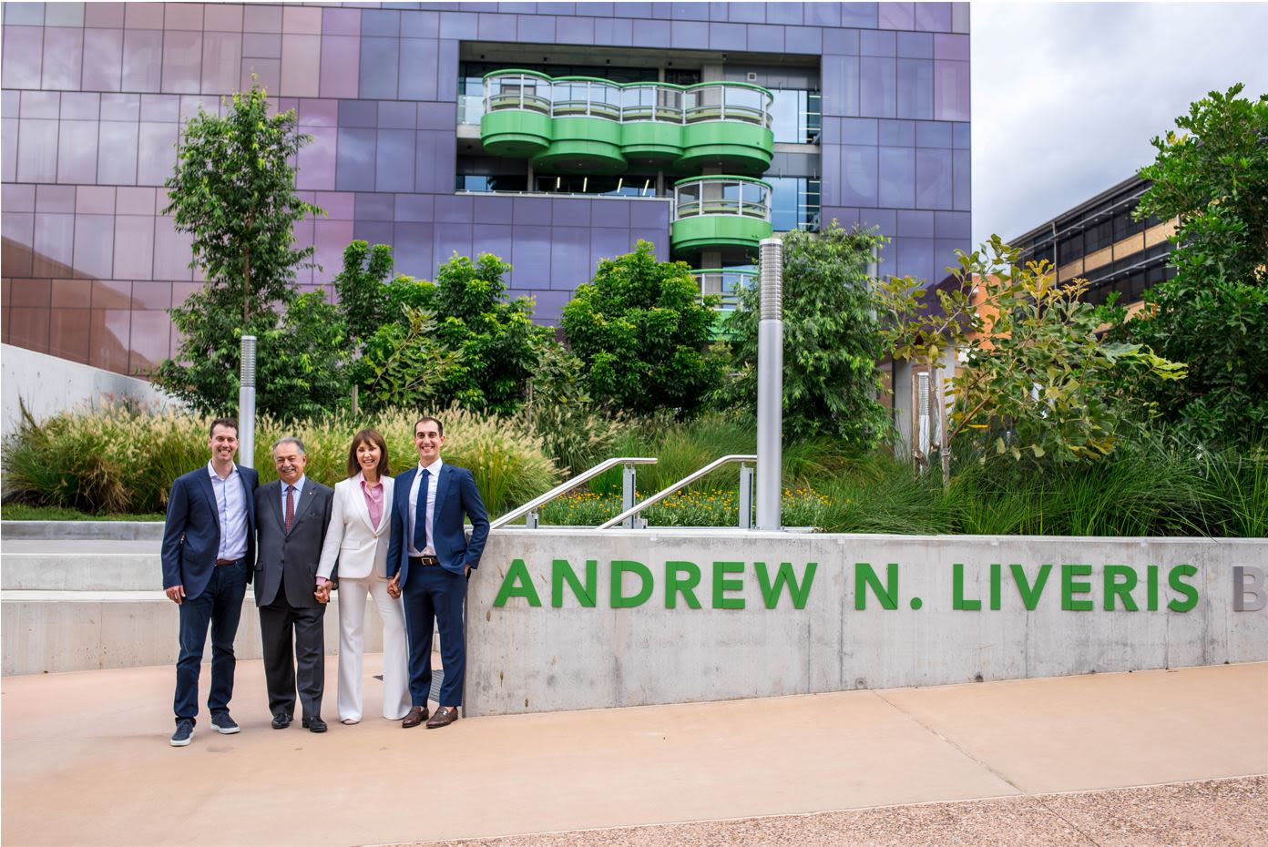 Andrew N. Liveris and his family stand in front of the building, next to a sign bearing his name