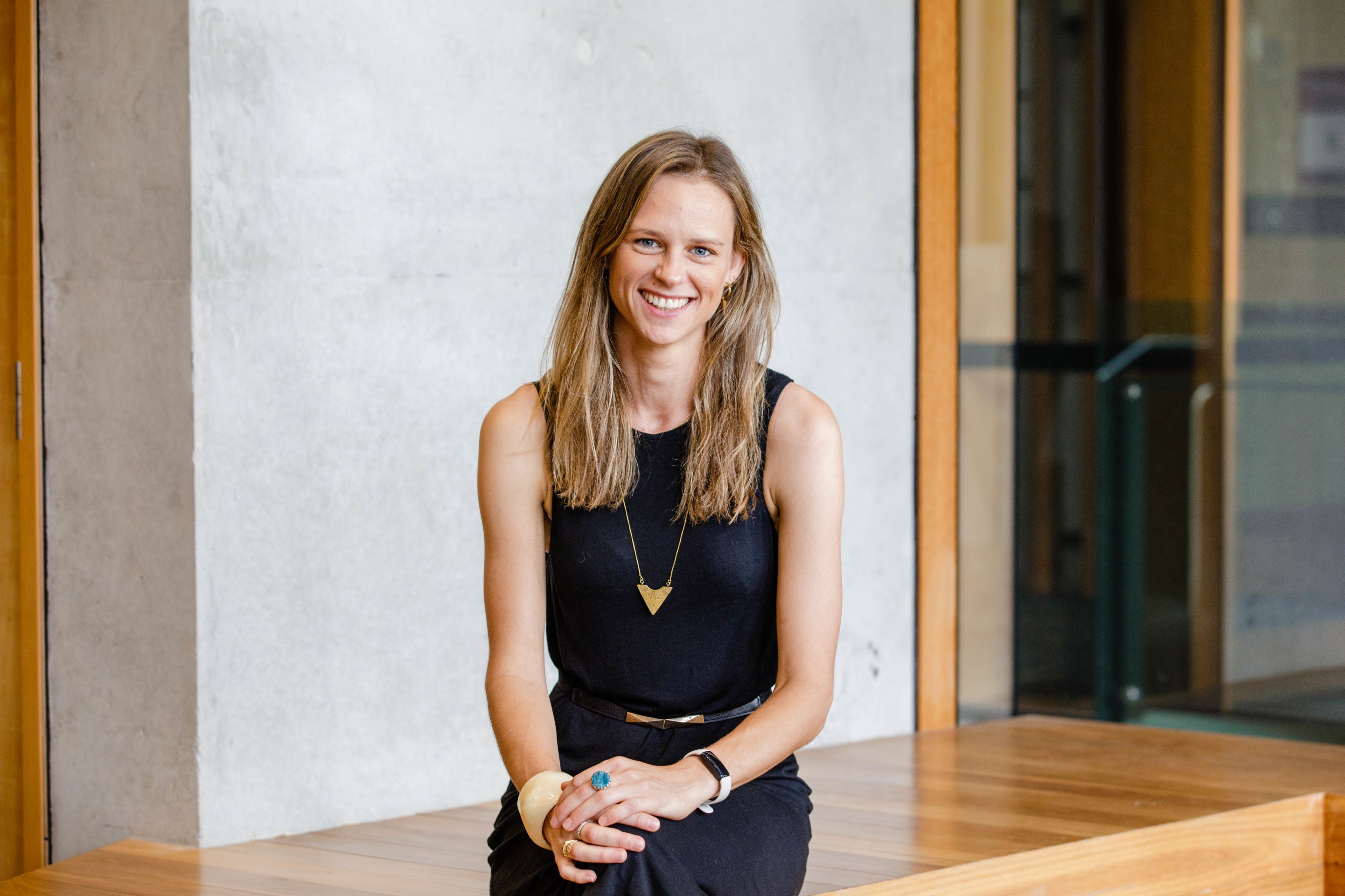 Eclipse founder, Siobhan Coster, wears a black singlet and is seated for the photo. She's smiling at the camera.