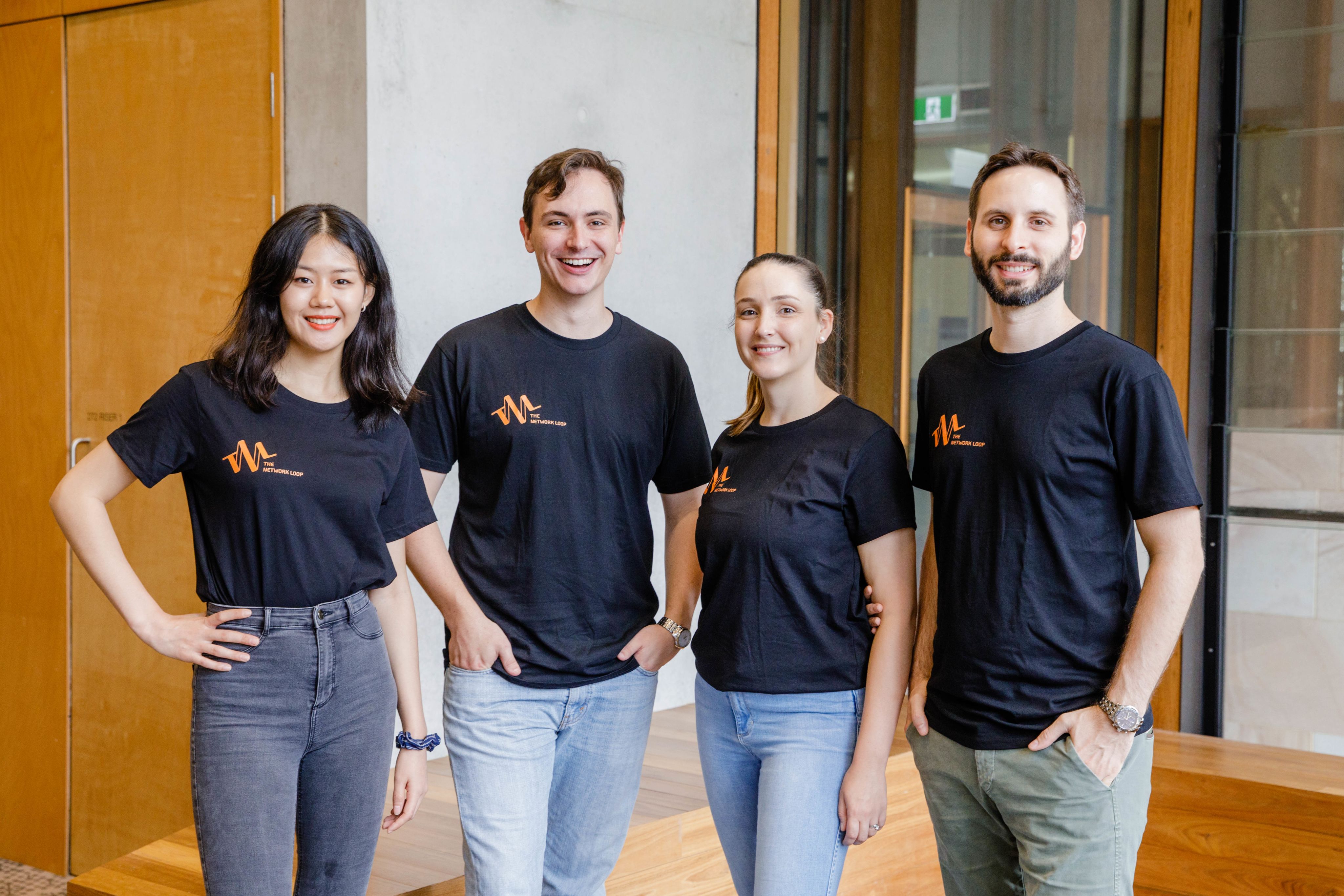Rachel Huang, Alexander Beard, Amelia St Baker and Andy St Baker-Radice - the founders of the Network Loop - stand in a group for a photo. They are all wearing black tops with the company logo