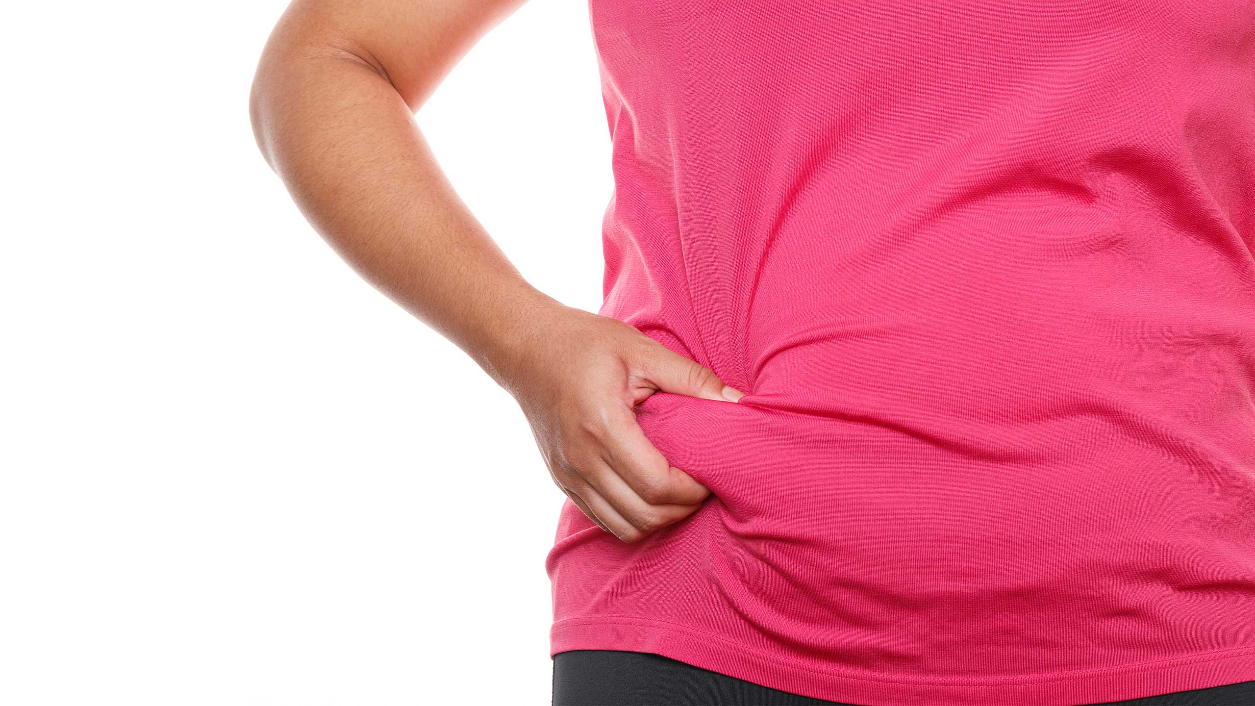 Woman wearing pink t-shirt pinching fat belly