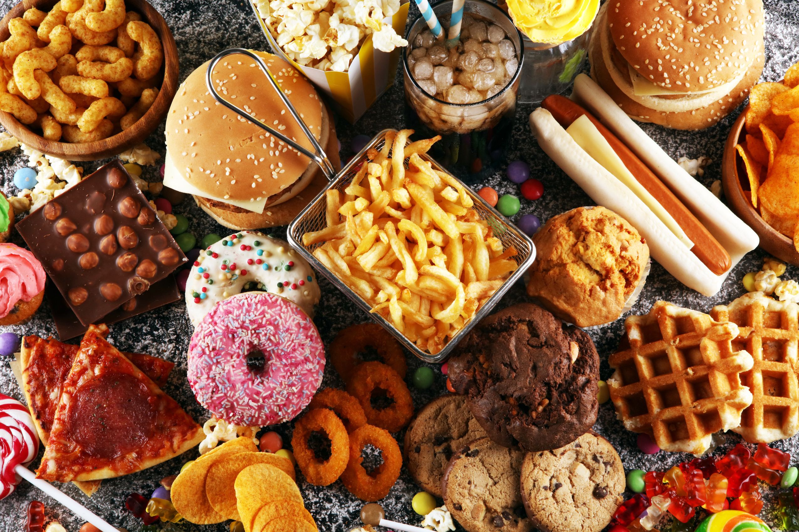 A selection ofjunk food including donuts, burgers, chips and pizza