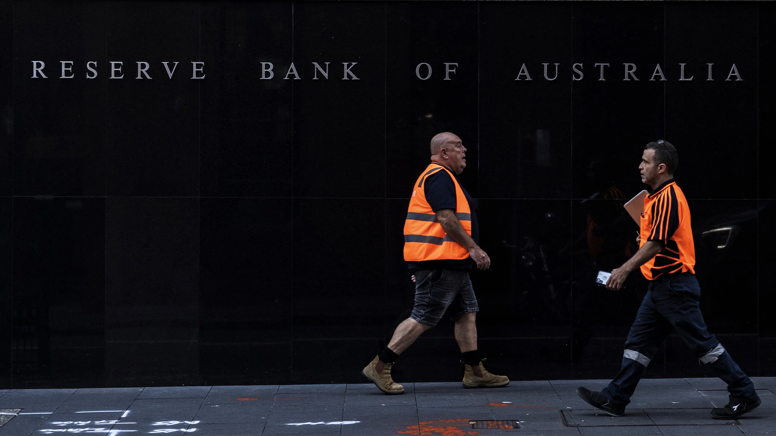 Pedestrians walk past the Reserve Bank of Australia headquarters.