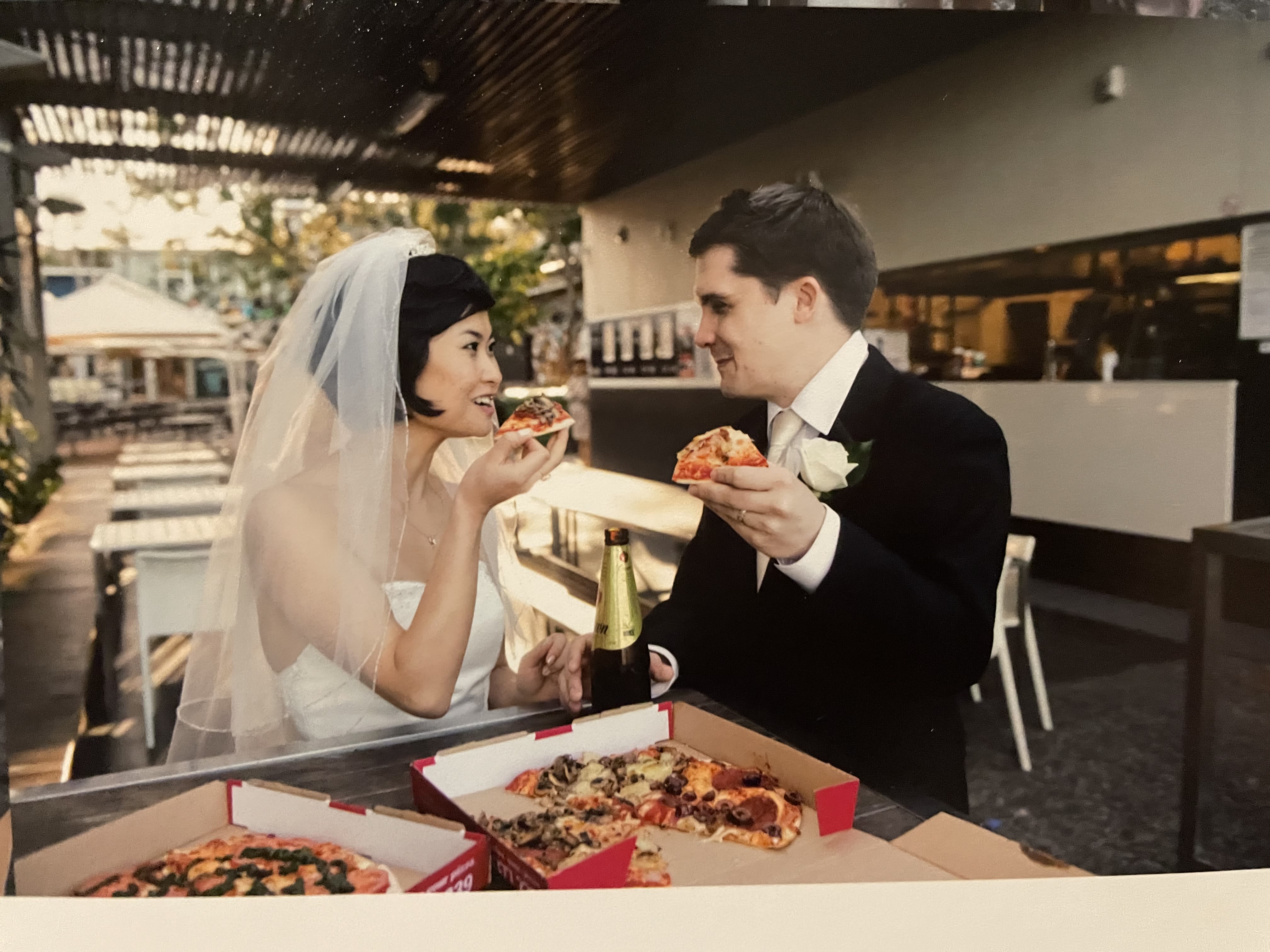 An image of Lei and Andrew on their wedding day eating at the UQ Pizza Cafe.