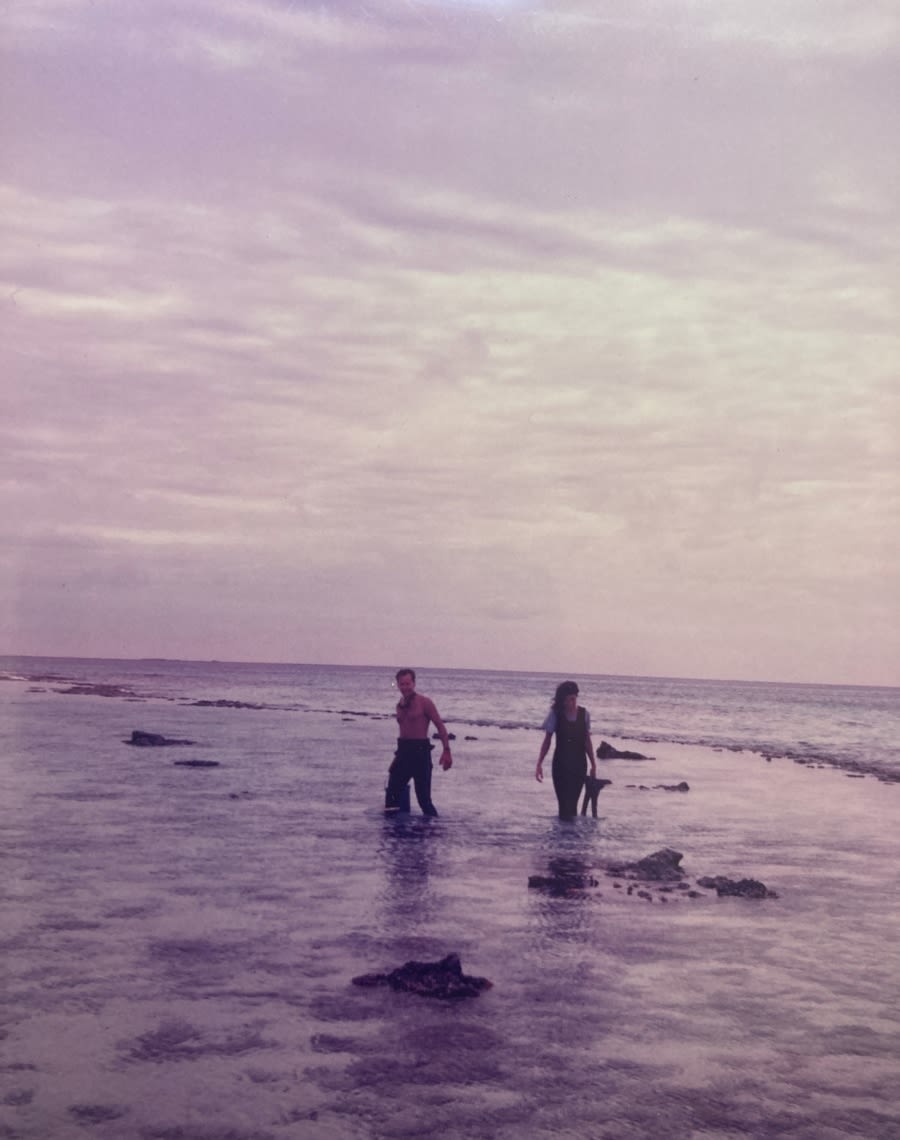 Professor Bernard Degnan and Professor Sandie Degnan standing in the ocean on a cloudy day