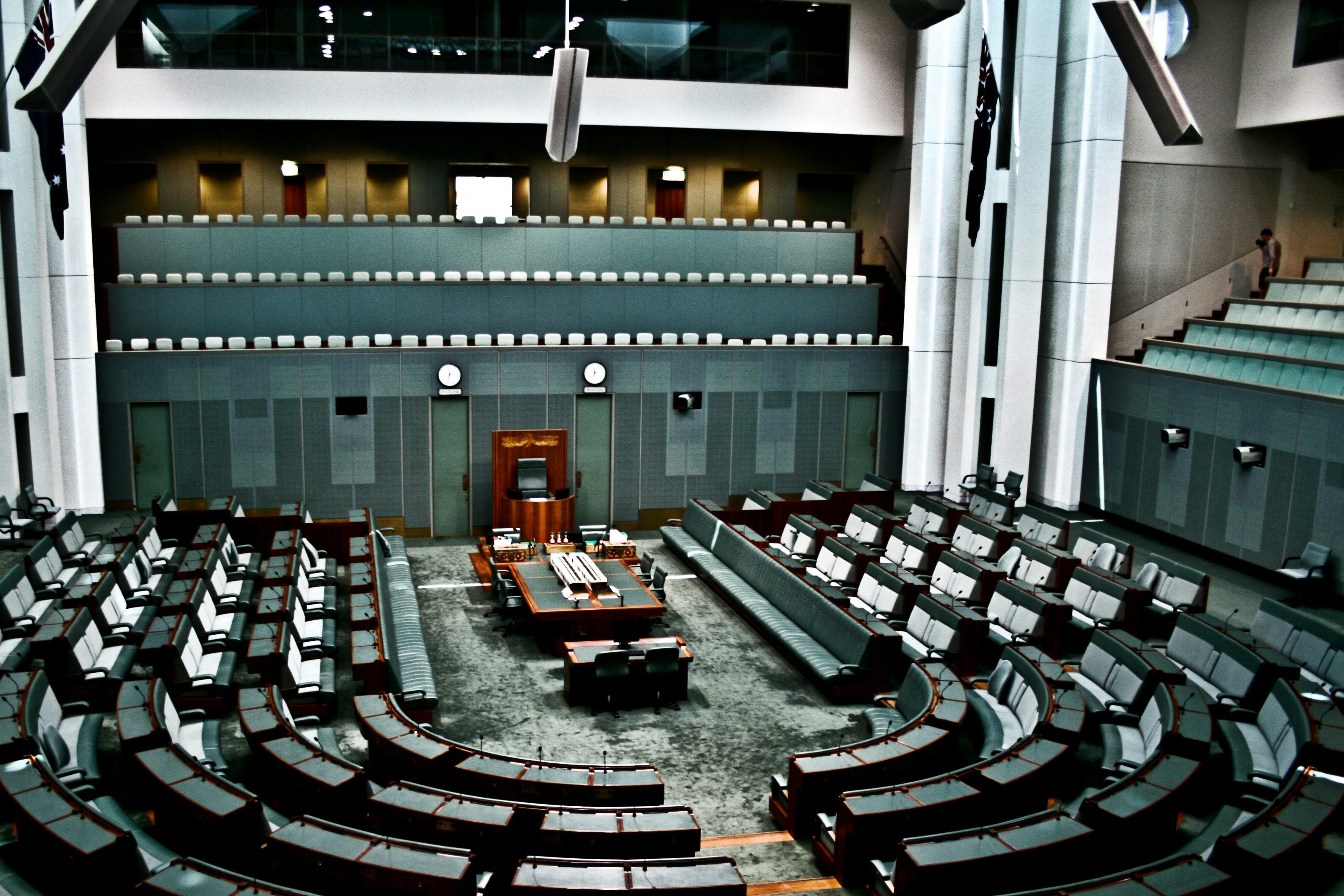 House of Representatives in Canberra. A mostly green room has chairs arranged in a U shape around the chair of the Speaker of the House, whose leather chair is elevated on a wooden platform.