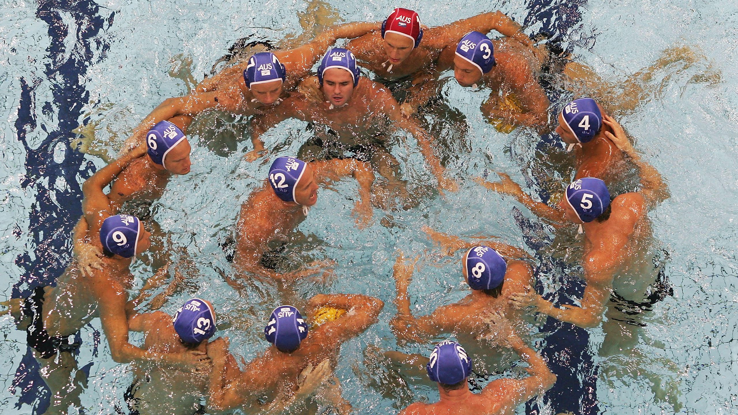 The Australian water polo team in a huddle in the pool during the Athens 2004 Olympics.