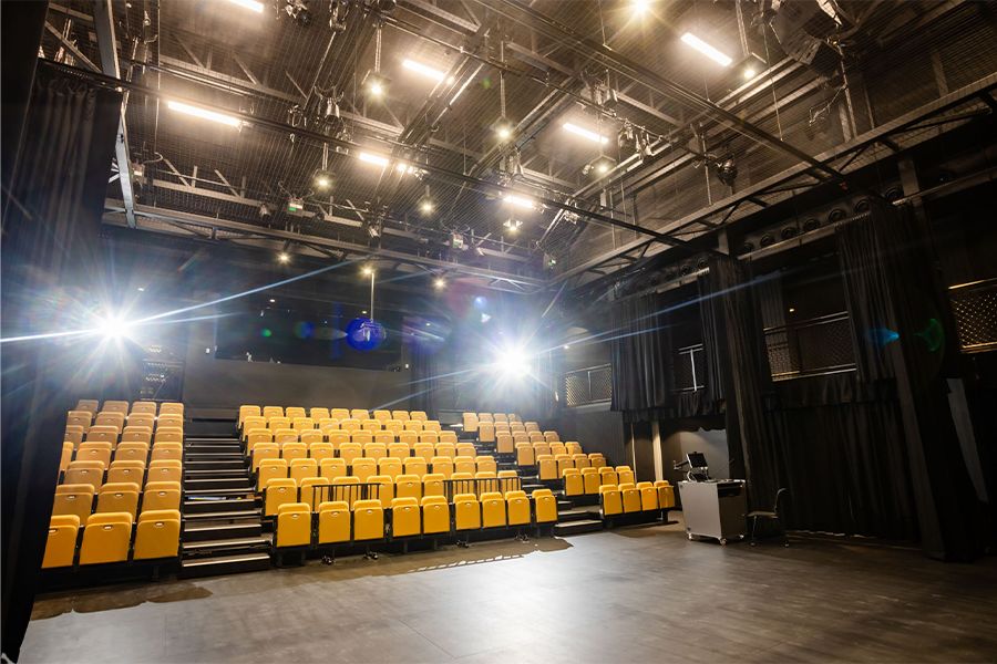 The inside of the large performance space with stage lighting and seating.