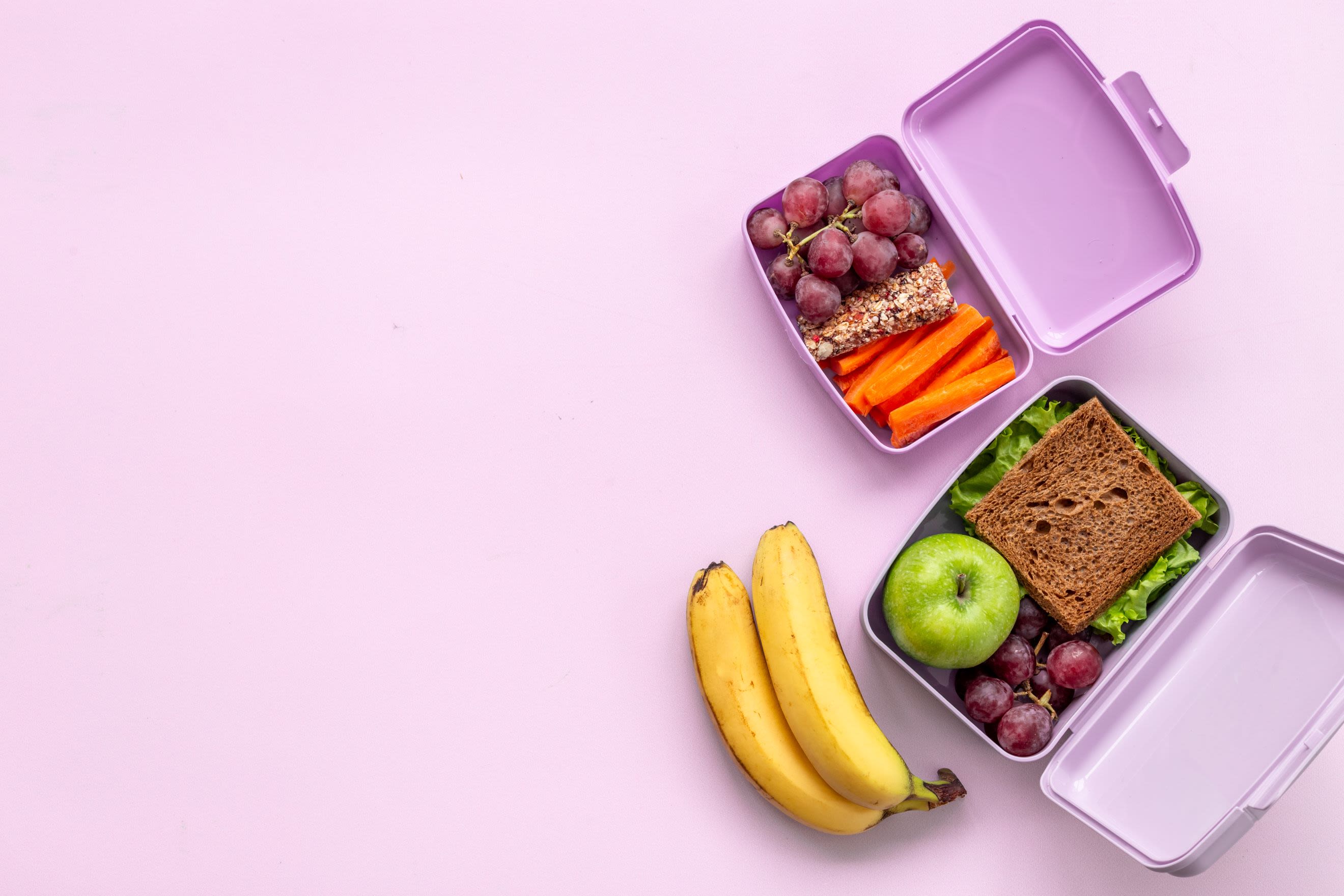 Healthy lunch boxes filled with fruits and vegetables, top view