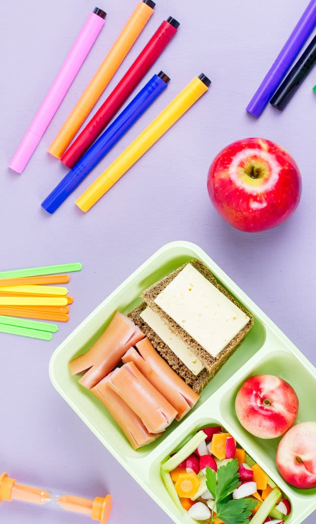 Top view of school lunch box surrounded by school supplies