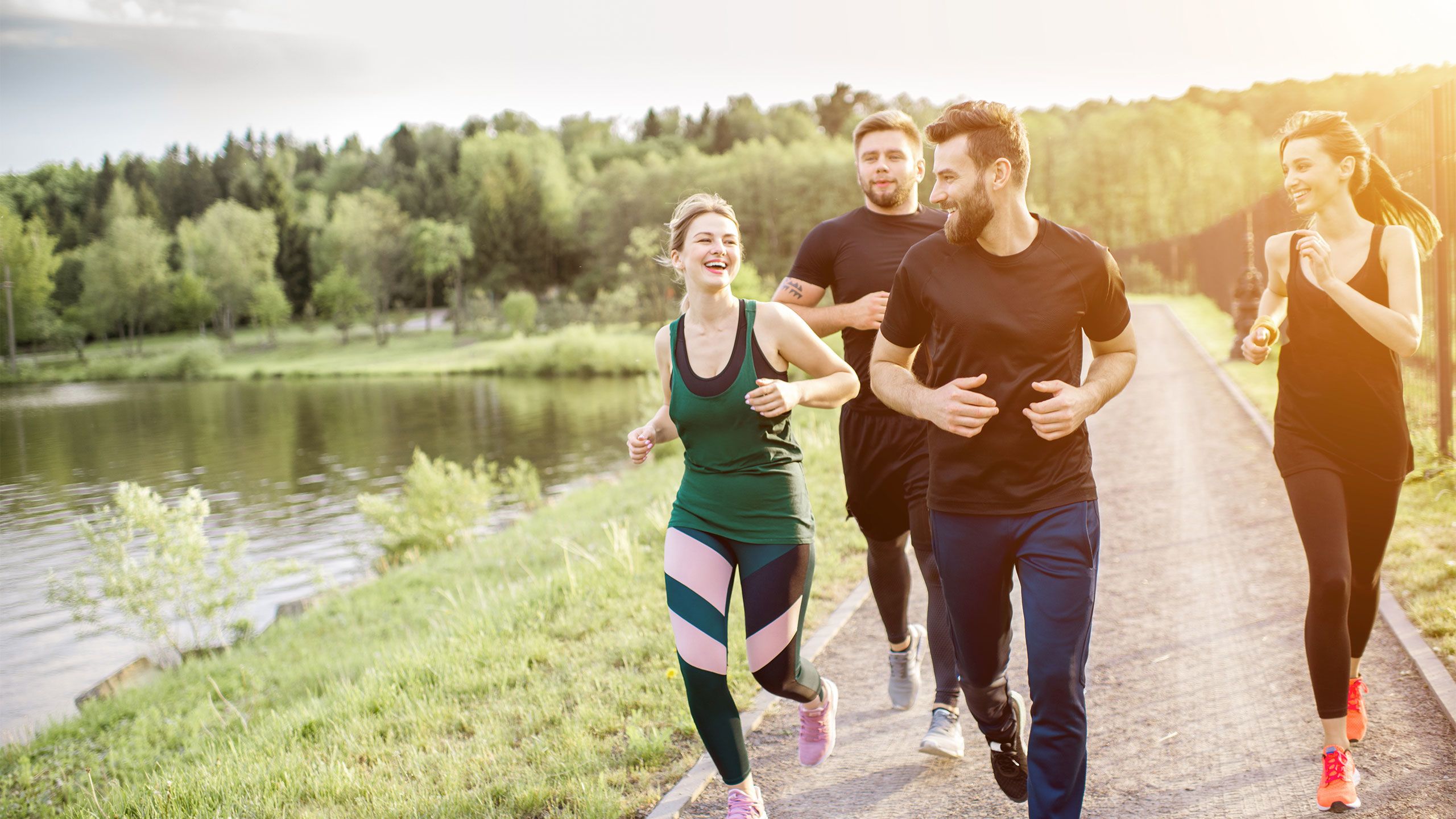 Friends jogging together by a lake.