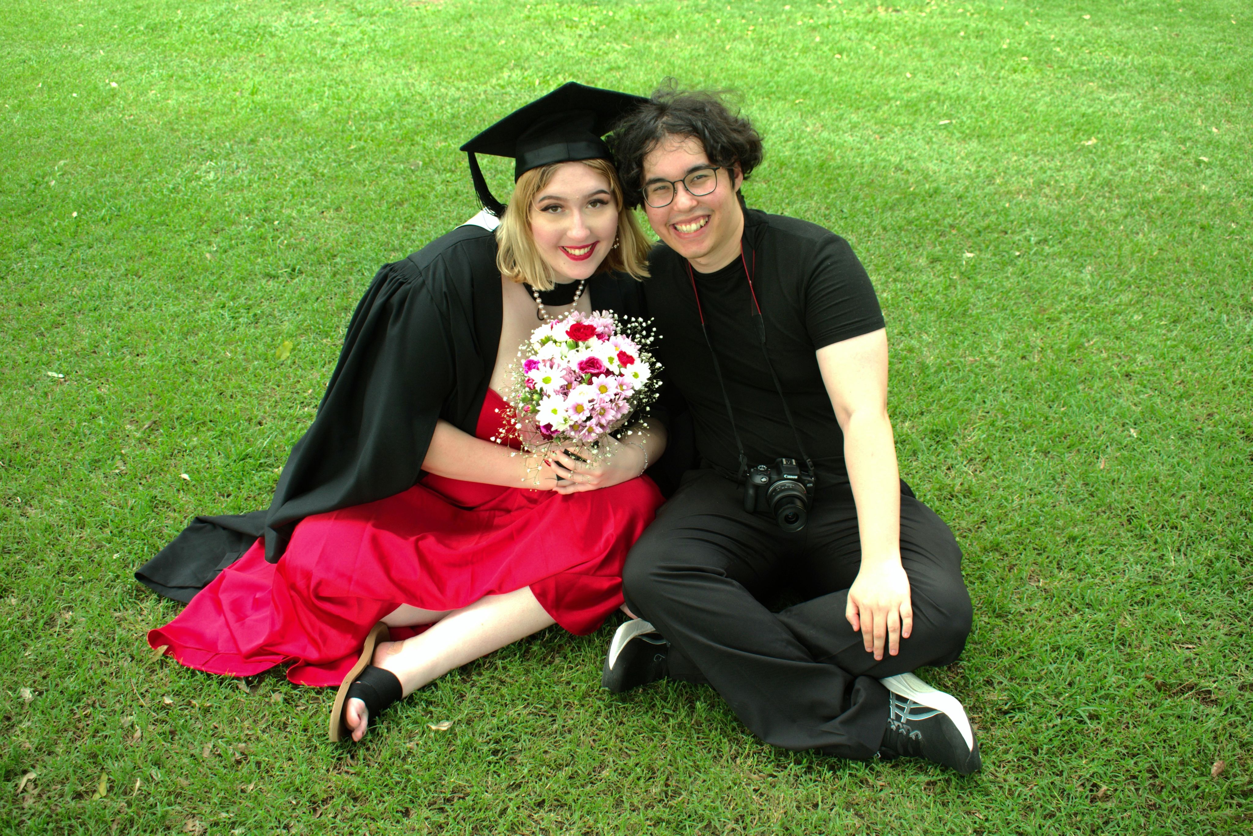 Francesca and Naran sitting on the Great Court, holding flowers
