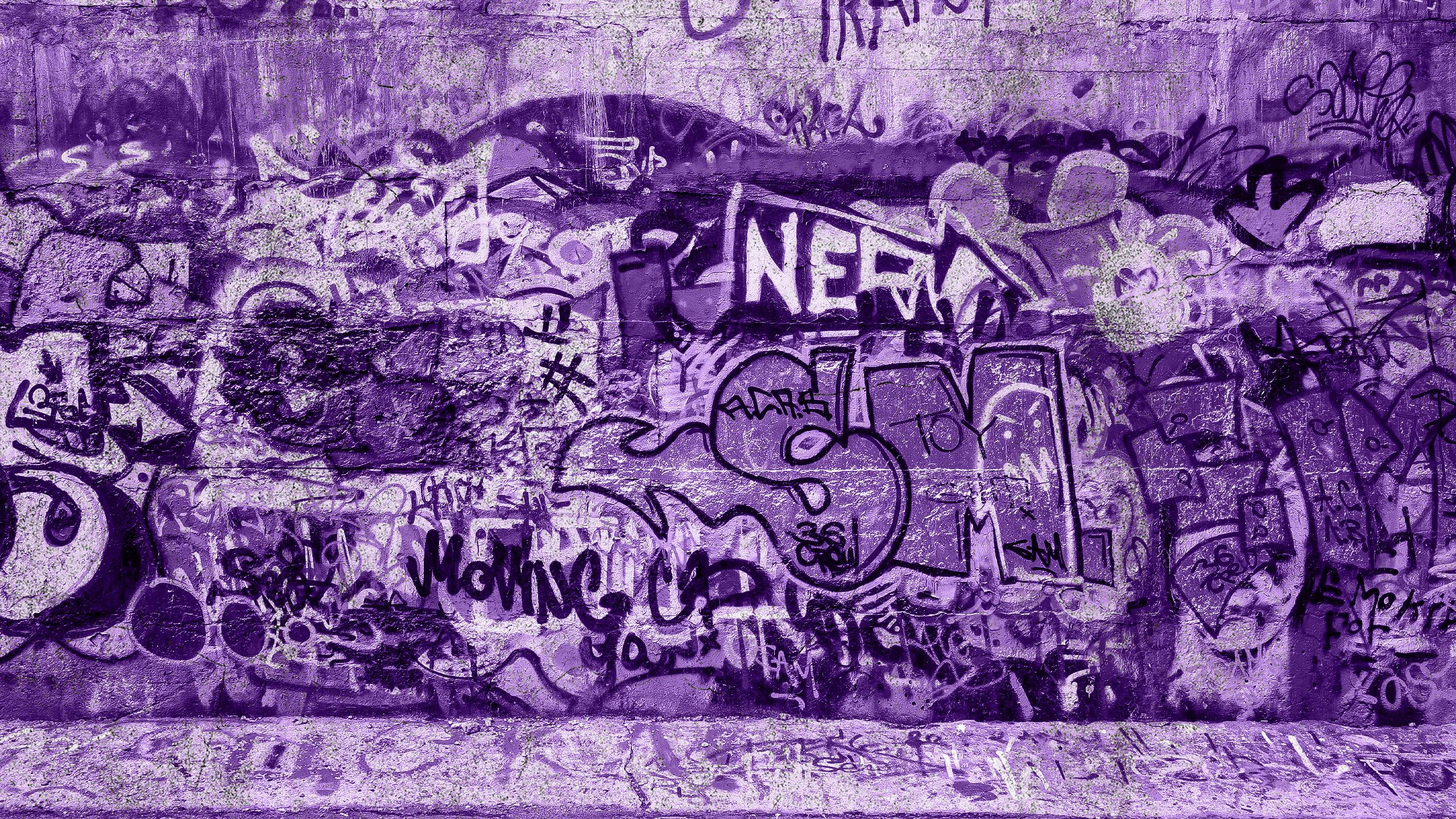 A gritty urban wall covered in graffiti.