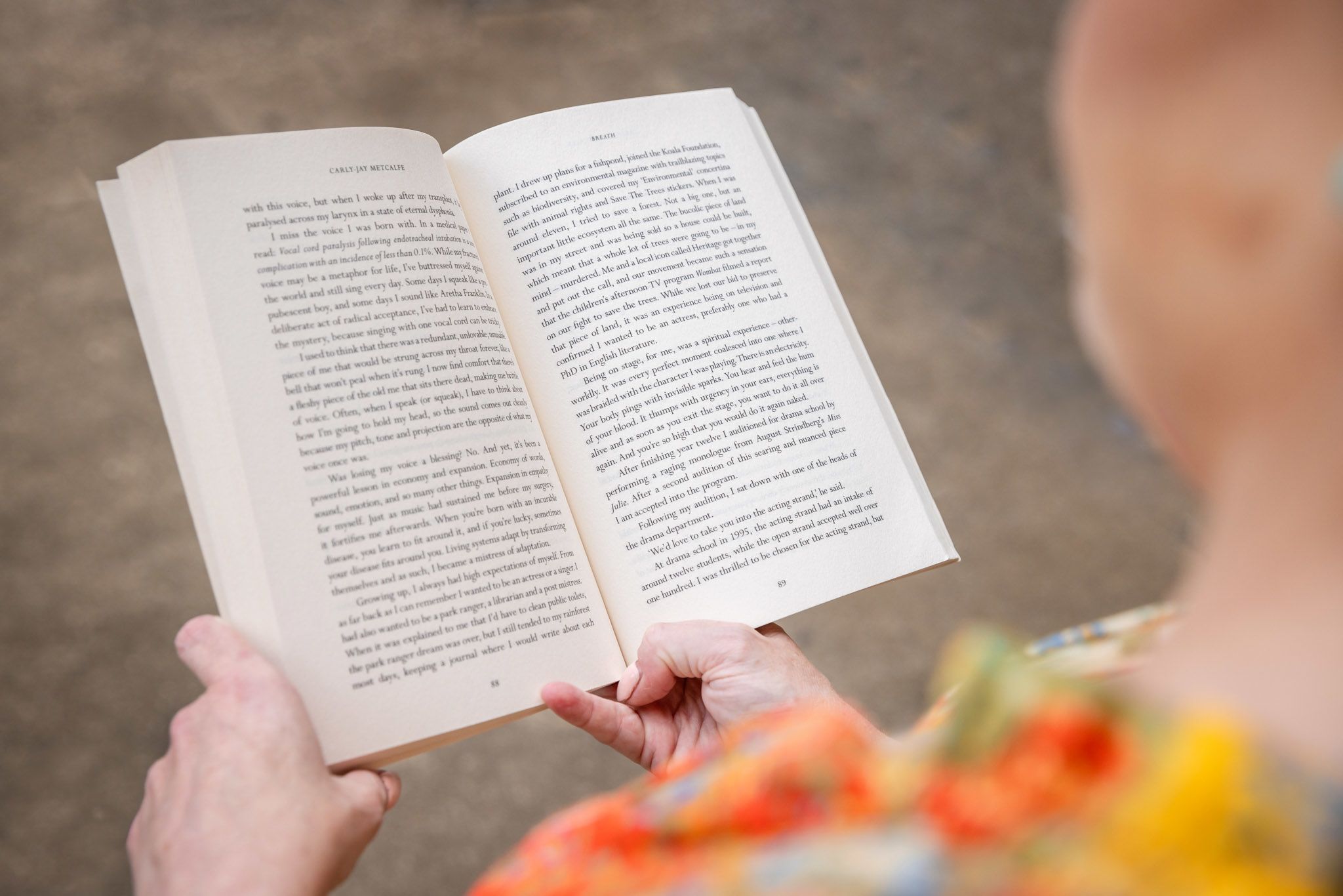 An image of Carly-Jay Metcalfe holding open her book, 'Breath'.