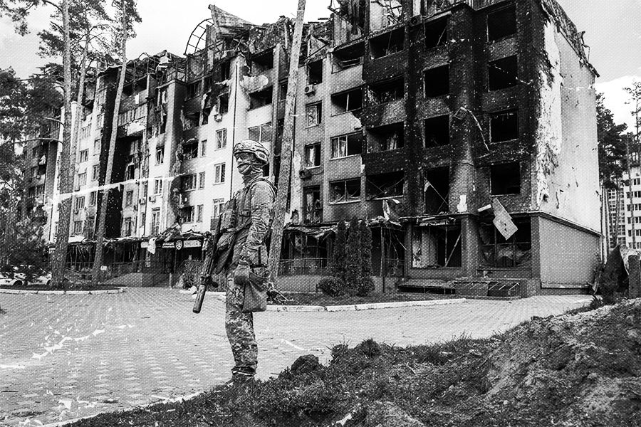 A Ukrainian army soldier stands guard outside a war damaged residential complex.