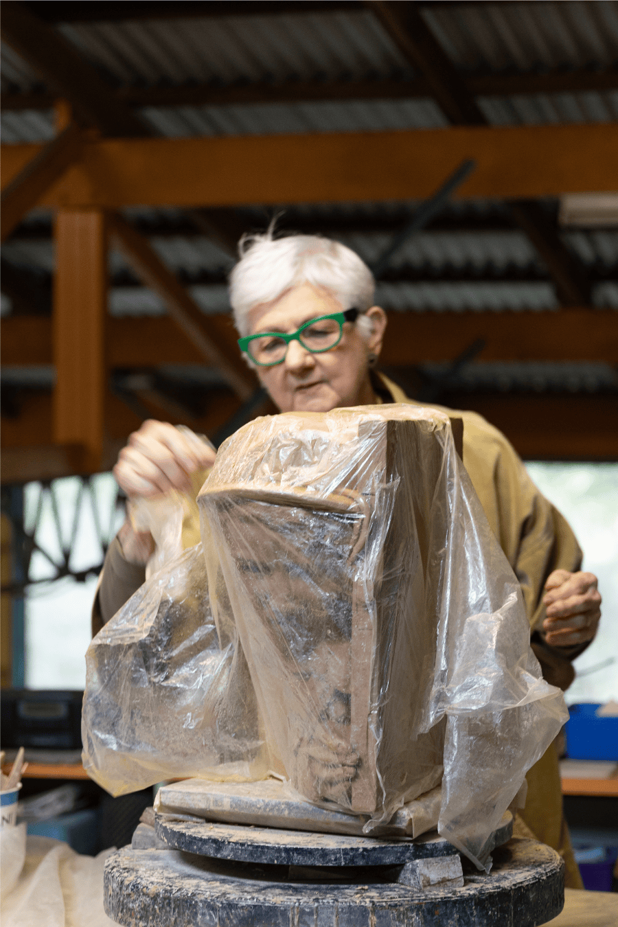 In her home studio, Hinwood unwraps the clay model of Valadian, which is usually covered in a plastic sheet for storage. 