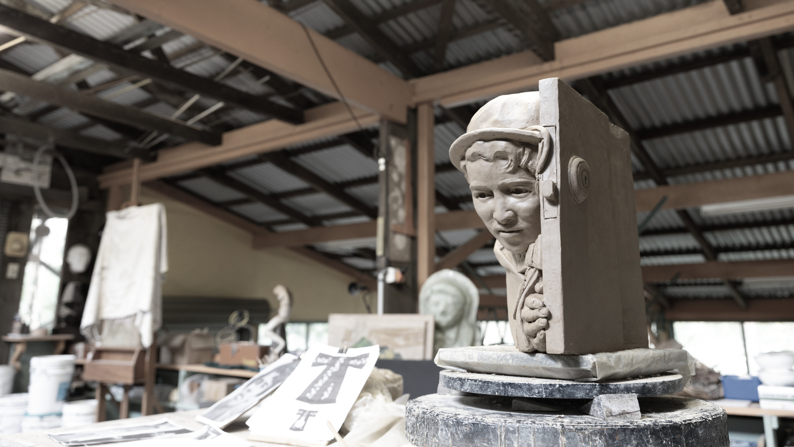 The maquette of Margaret Valadian sits on Hinwood's work bench, with tools and images the Officer of the Order of Australia insignia laying beside it.