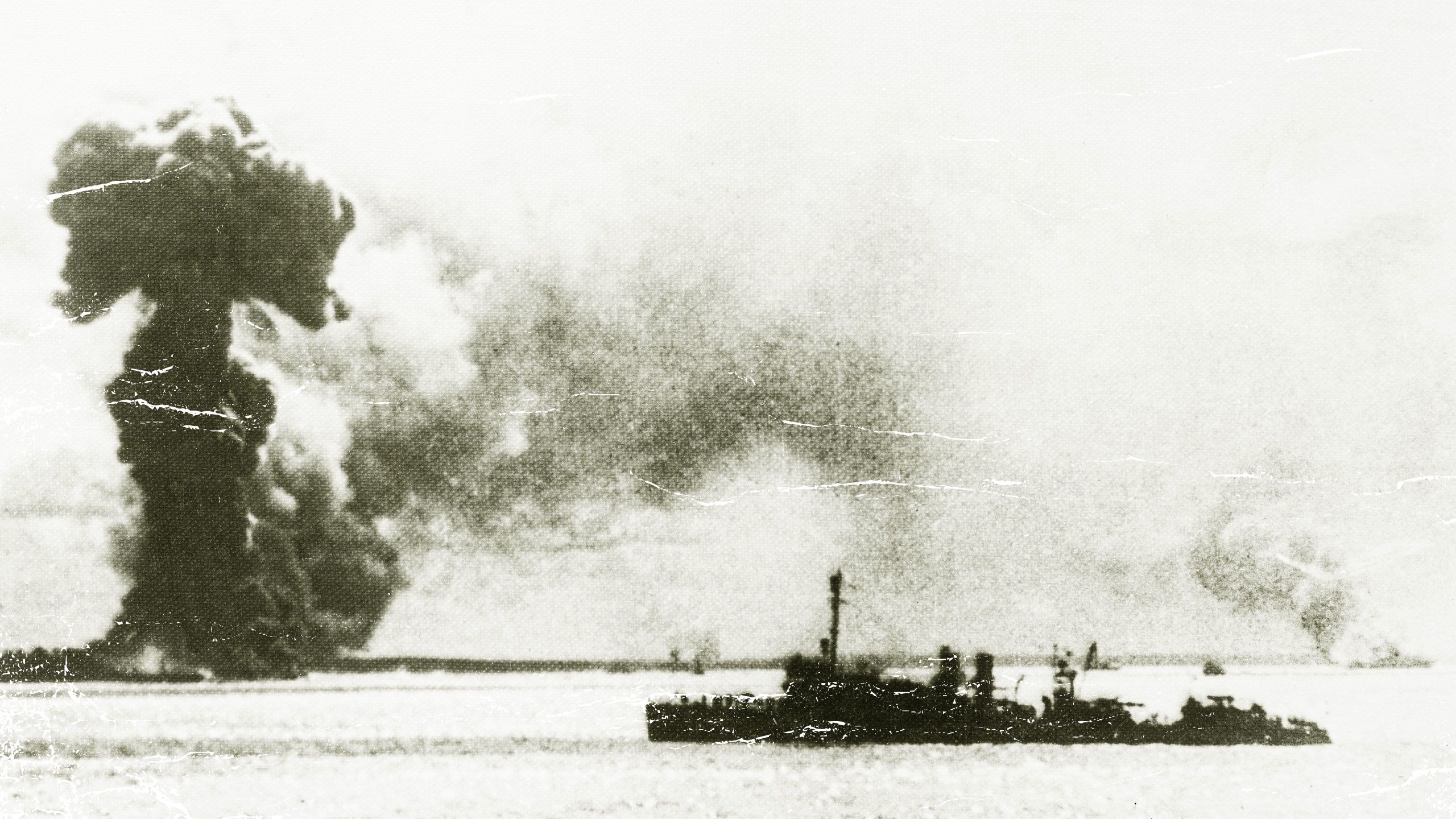 A Japanese air attack on Port Darwin during World War II in 1942. In the foreground is a US destroyer, and behind it are the burning remains of an Australian hospital ship and a British ship.