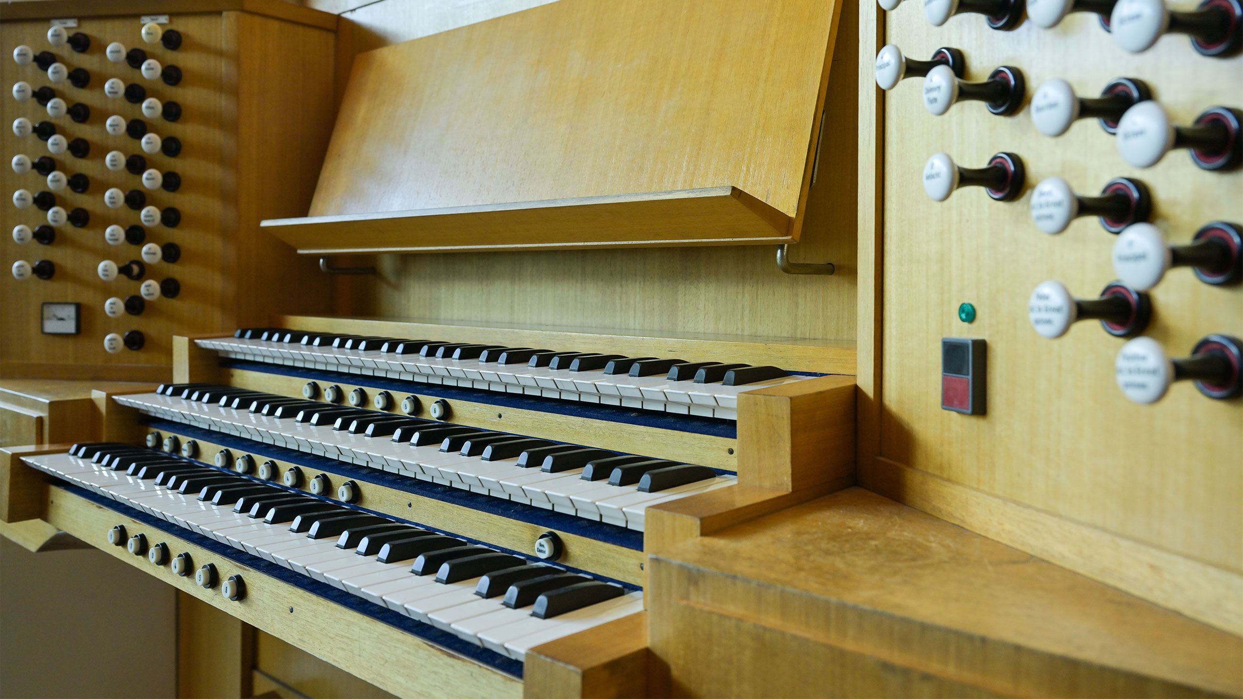 Close up of the three keyboards and stops of the UQ pipe organ.