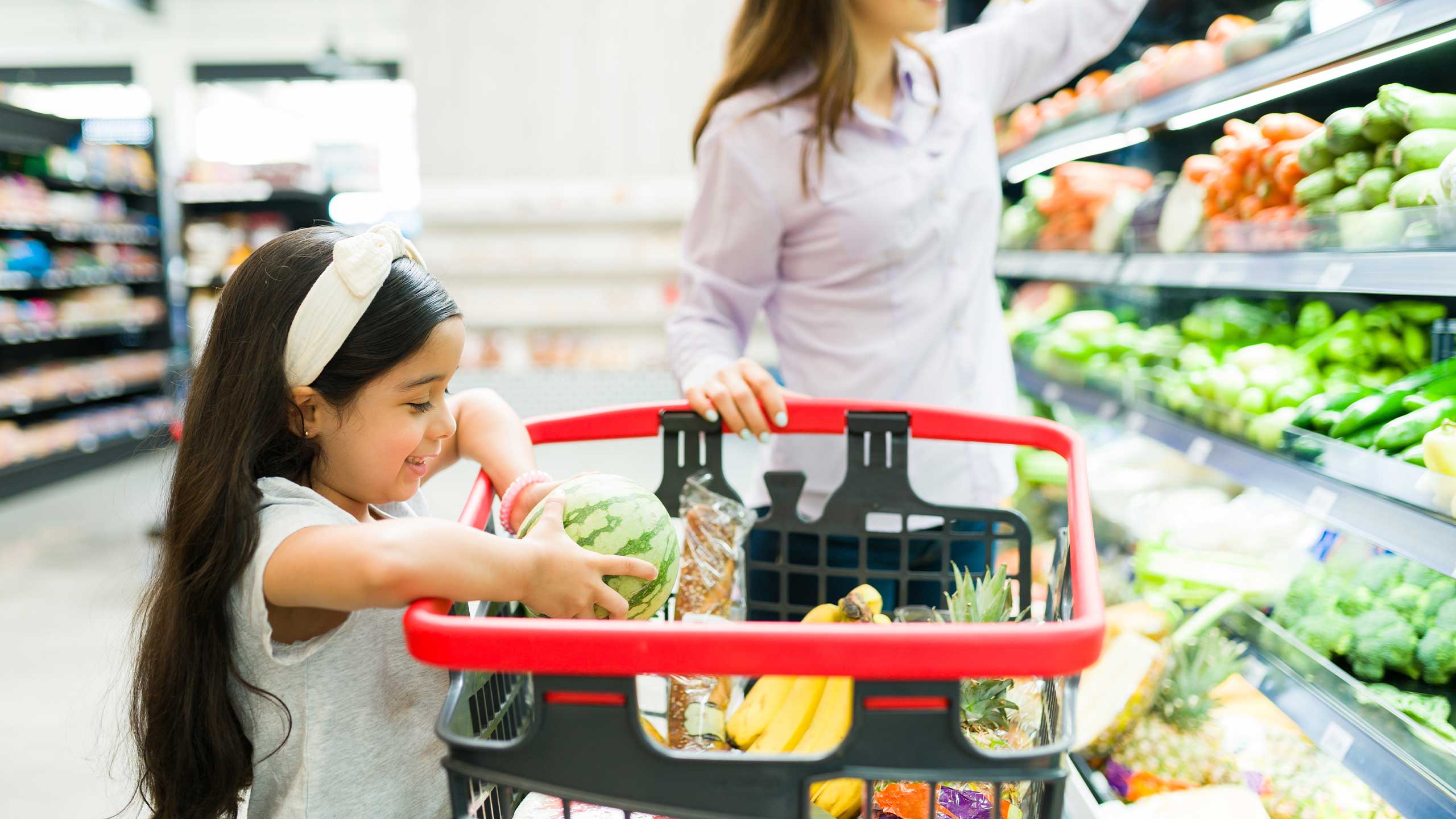 A young girl helping her mum do the grocery shopping.