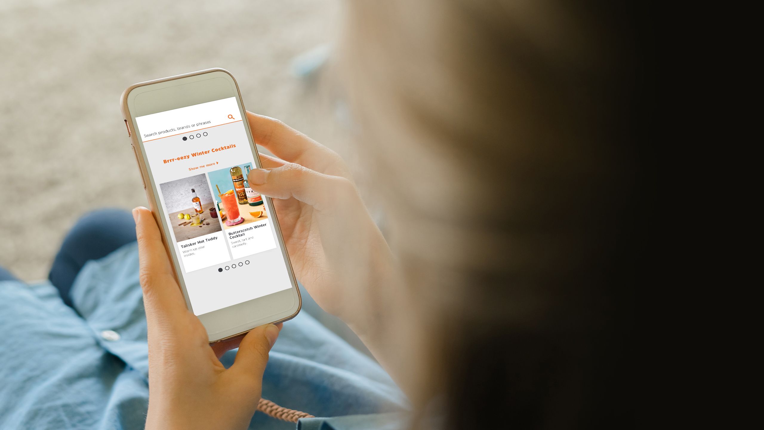 Teenage girl sitting on an armchair while holding a smart phone looking at alcohol ads.