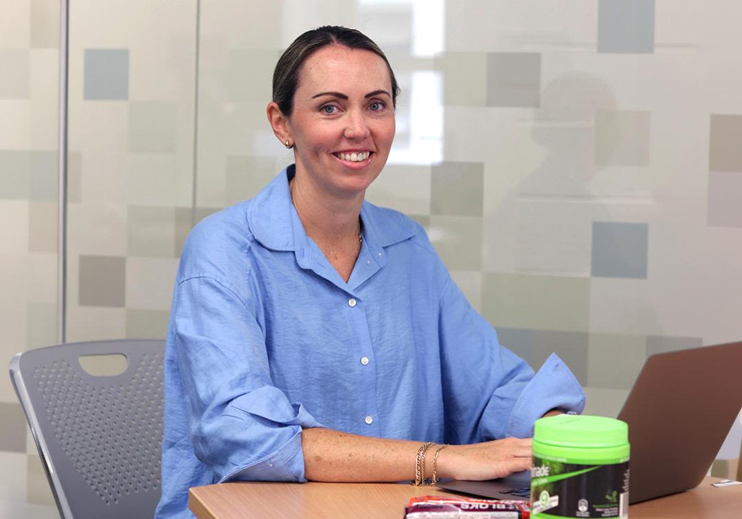 A photograph of Dr Brooke Devlin at her computer