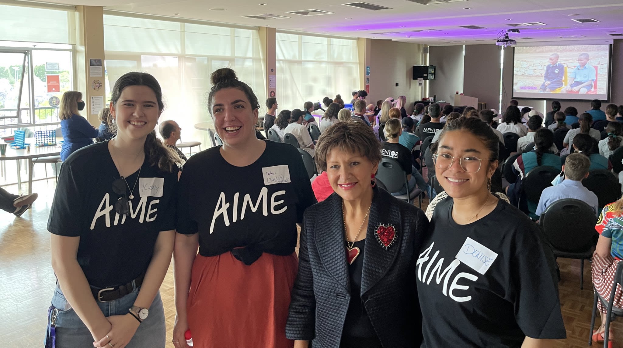 A group of high school students wearing black shirts with AIME written in white.