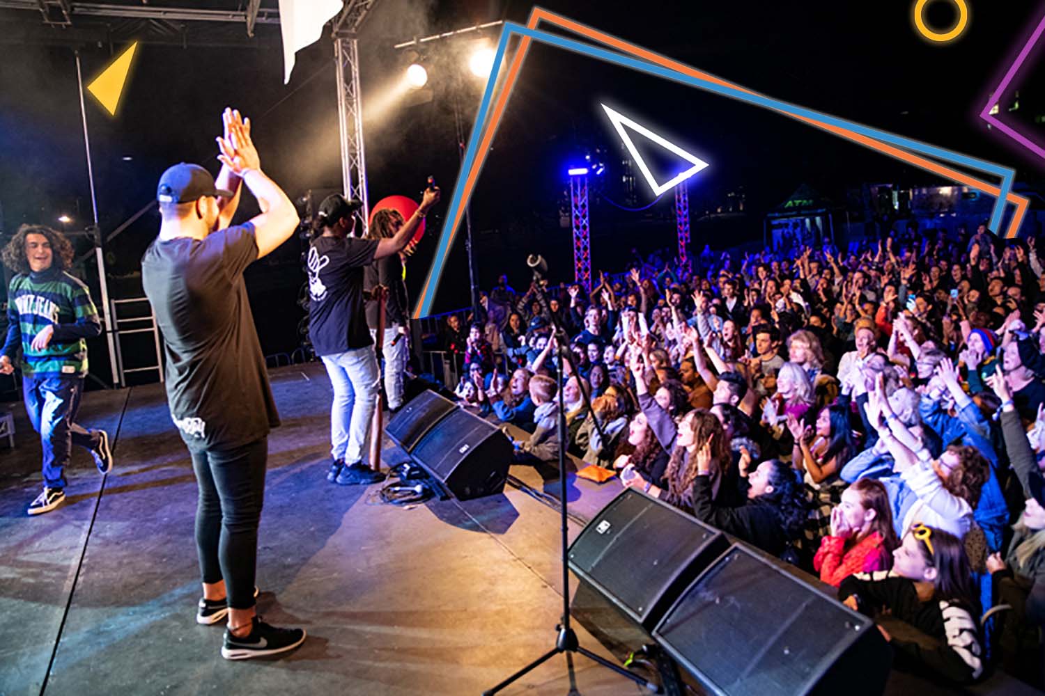 Musicians perform onstage in front of a large crowd.
