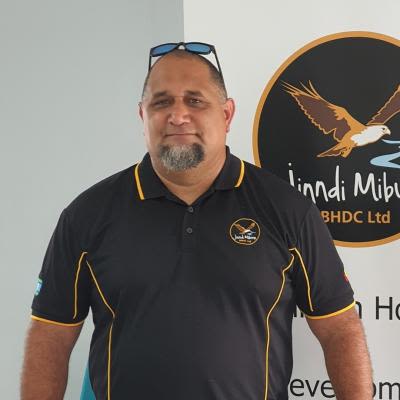 A headshot of Will Davis, a middle-aged man, standing in front of banner with an illustration of an eagle and text reading 'Jinndi Mibunn'