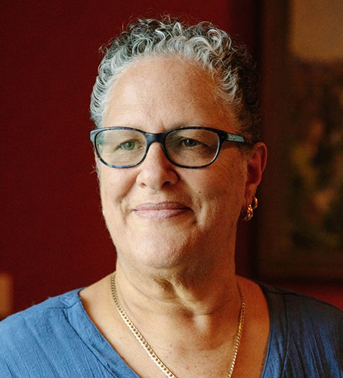 Stephanie Gilbert, a woman with short grey curly hair, looking into the distance