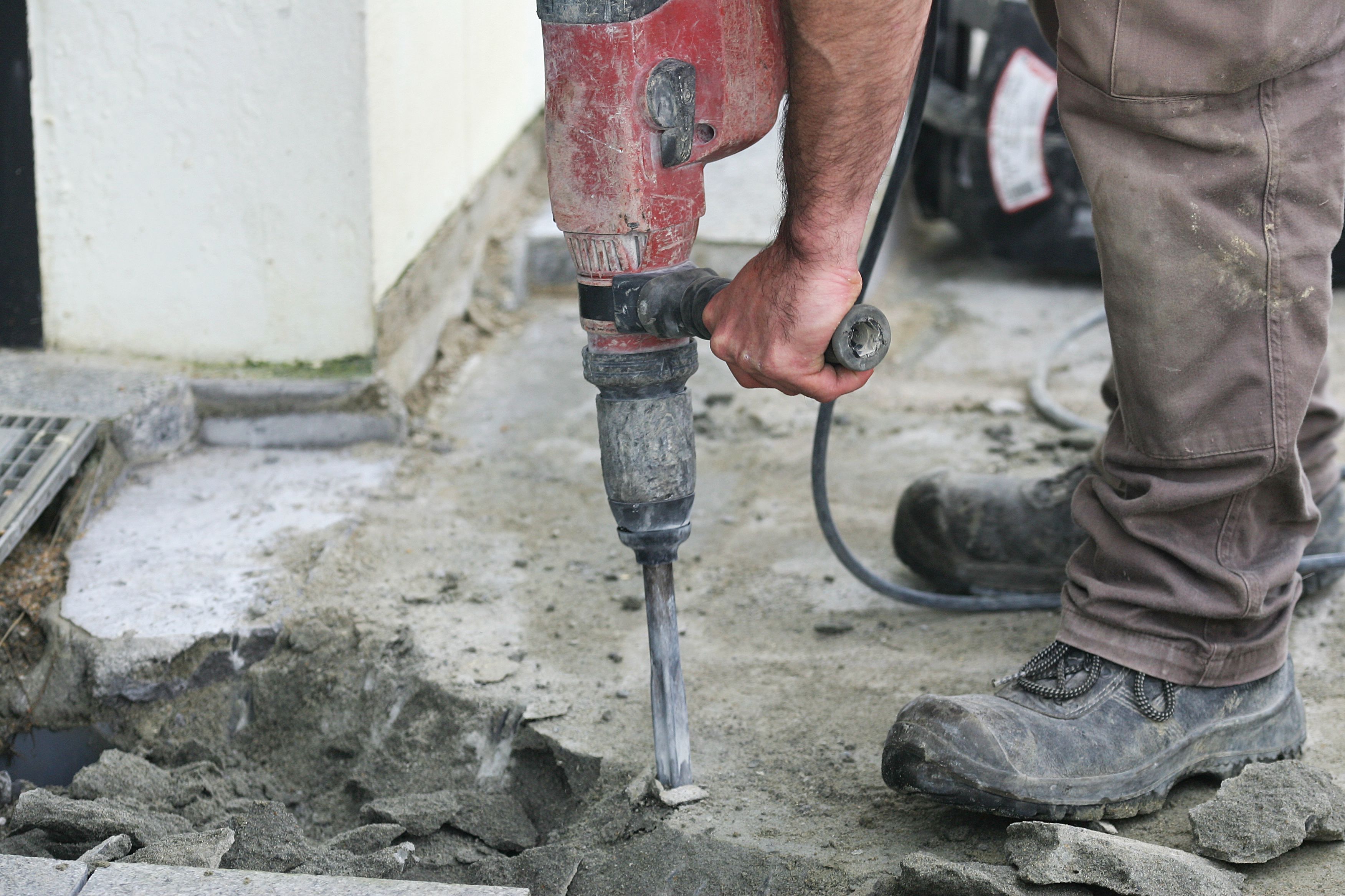 Workers drilling into concrete floor
