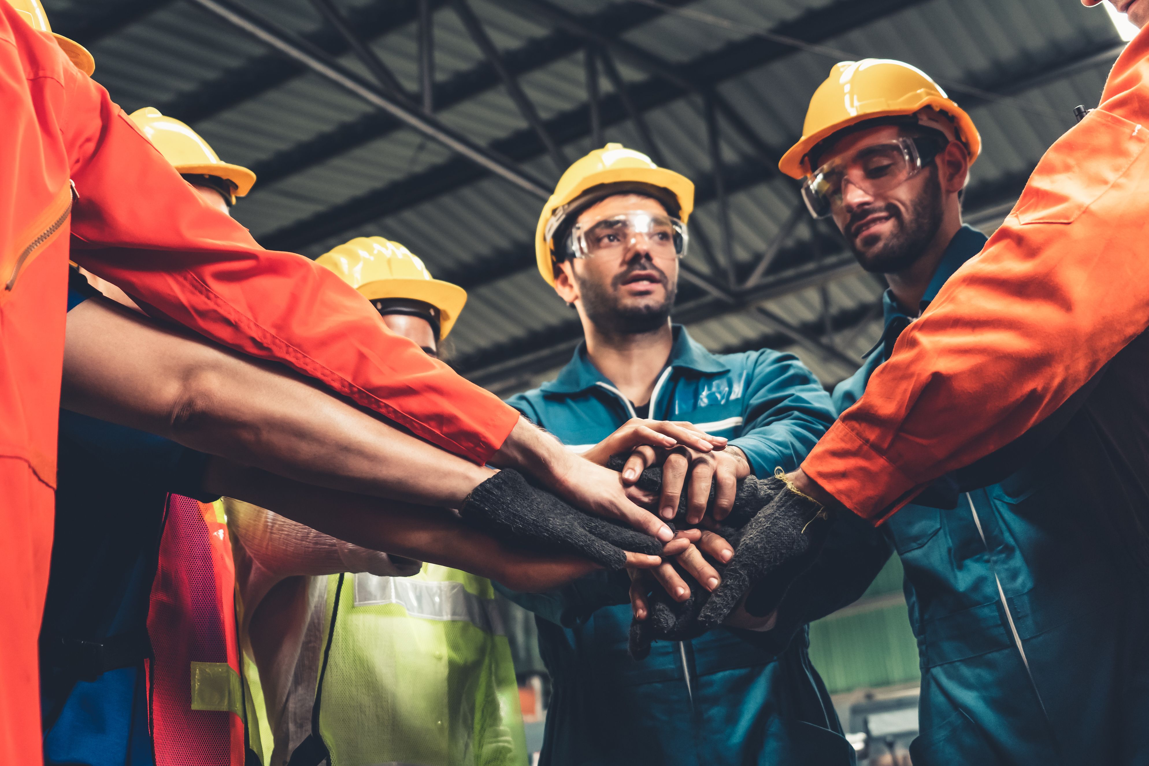 Workers in hard hats and hi vis showing teamwork
