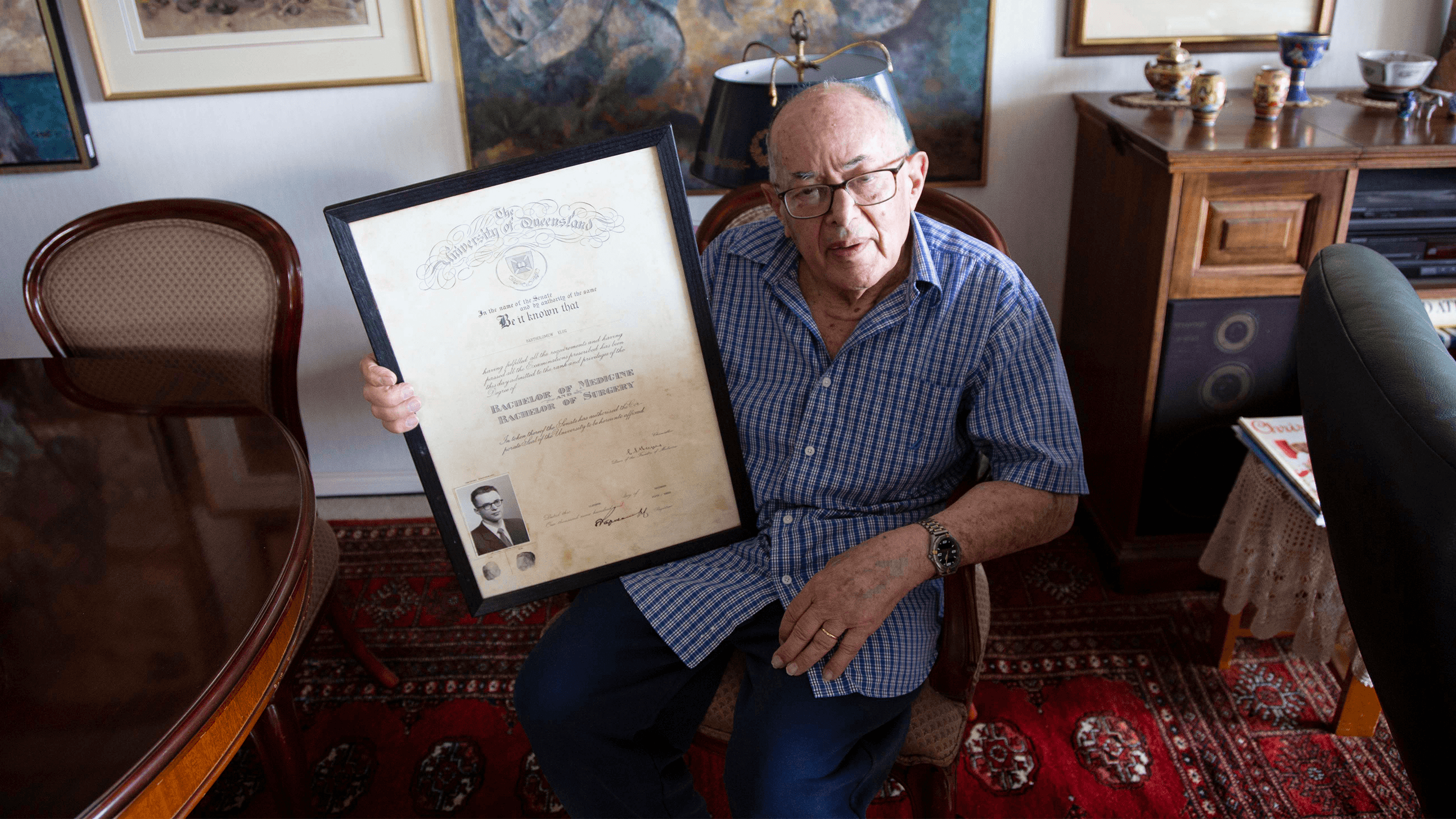 Dr Bert Klug holding UQ medical degree