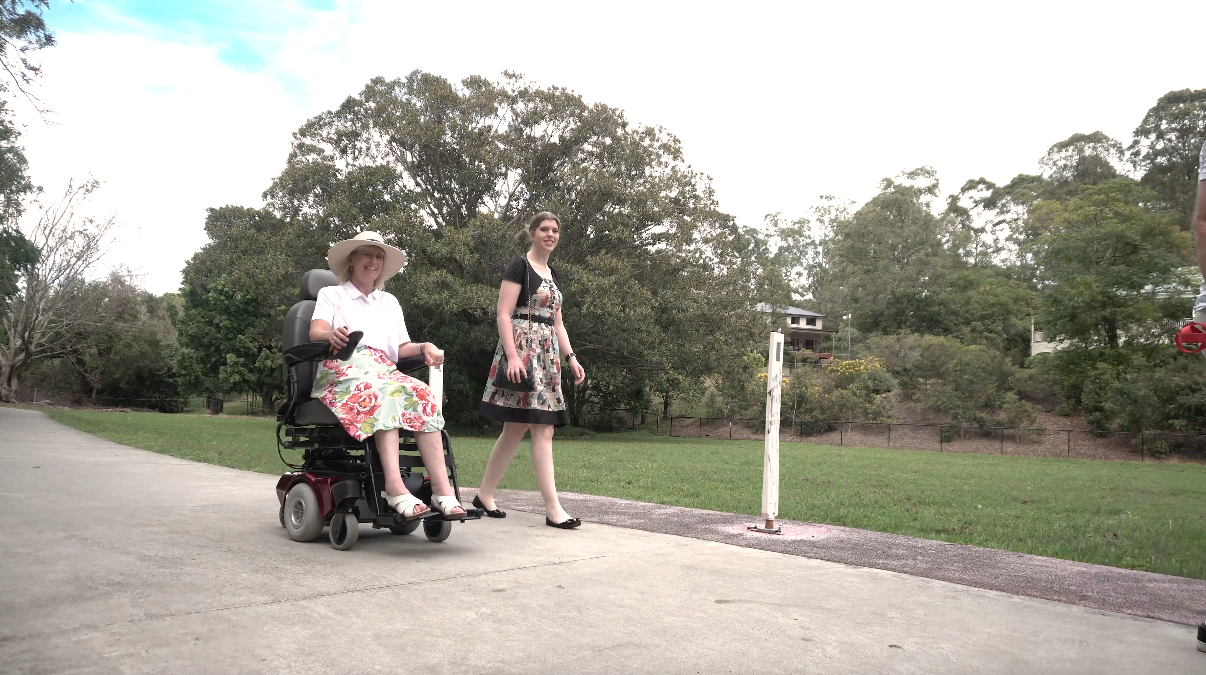 woman walking next to woman in wheelchair with MS.