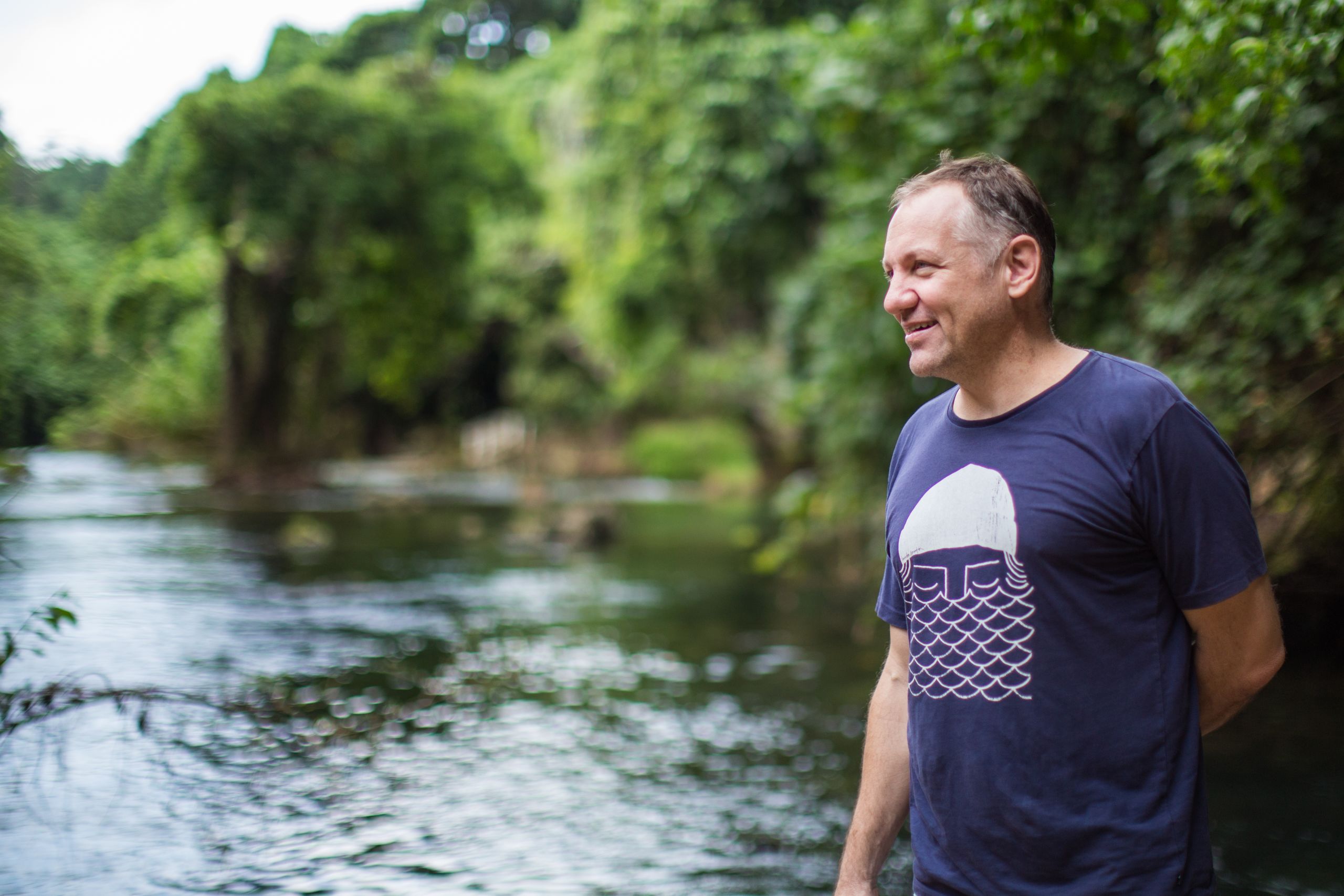 man gazes out across stream