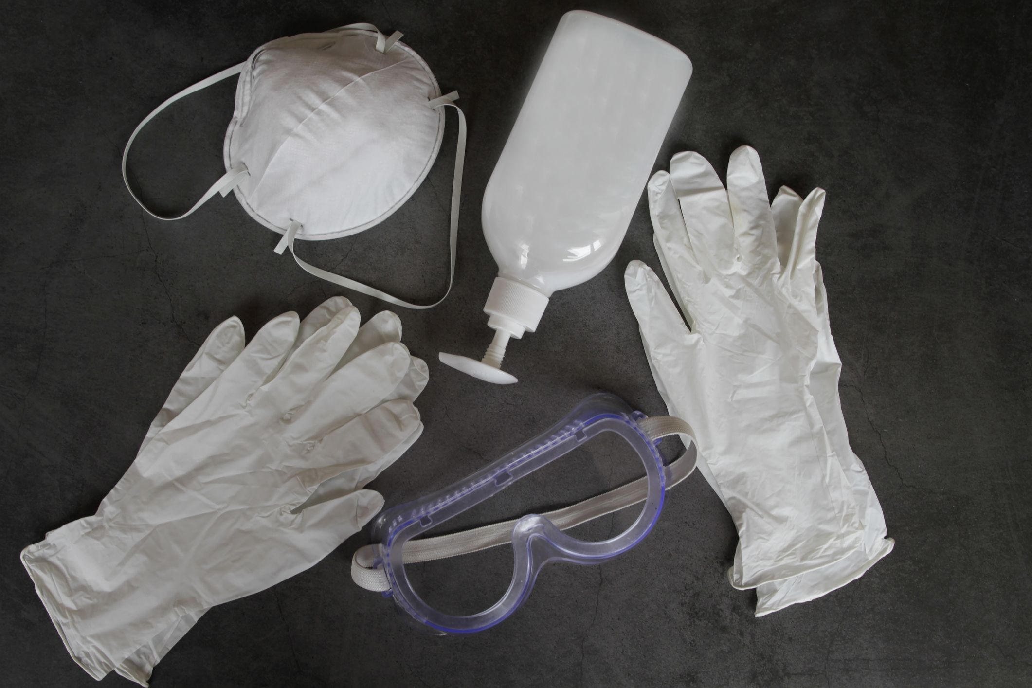 Personal protective equipment (PPE) with plastic gloves, mask, goggles and santiser.