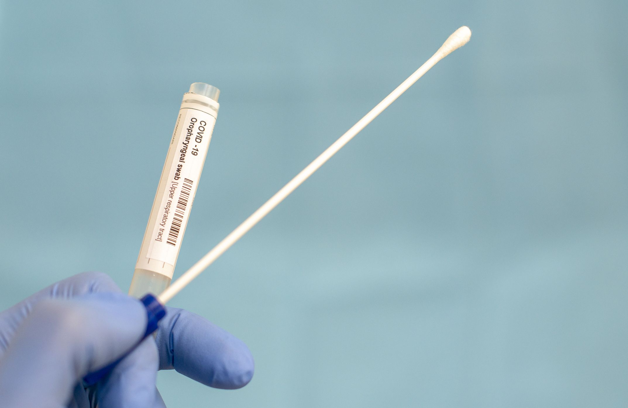 COVID-19 swab testing kit against blue background.