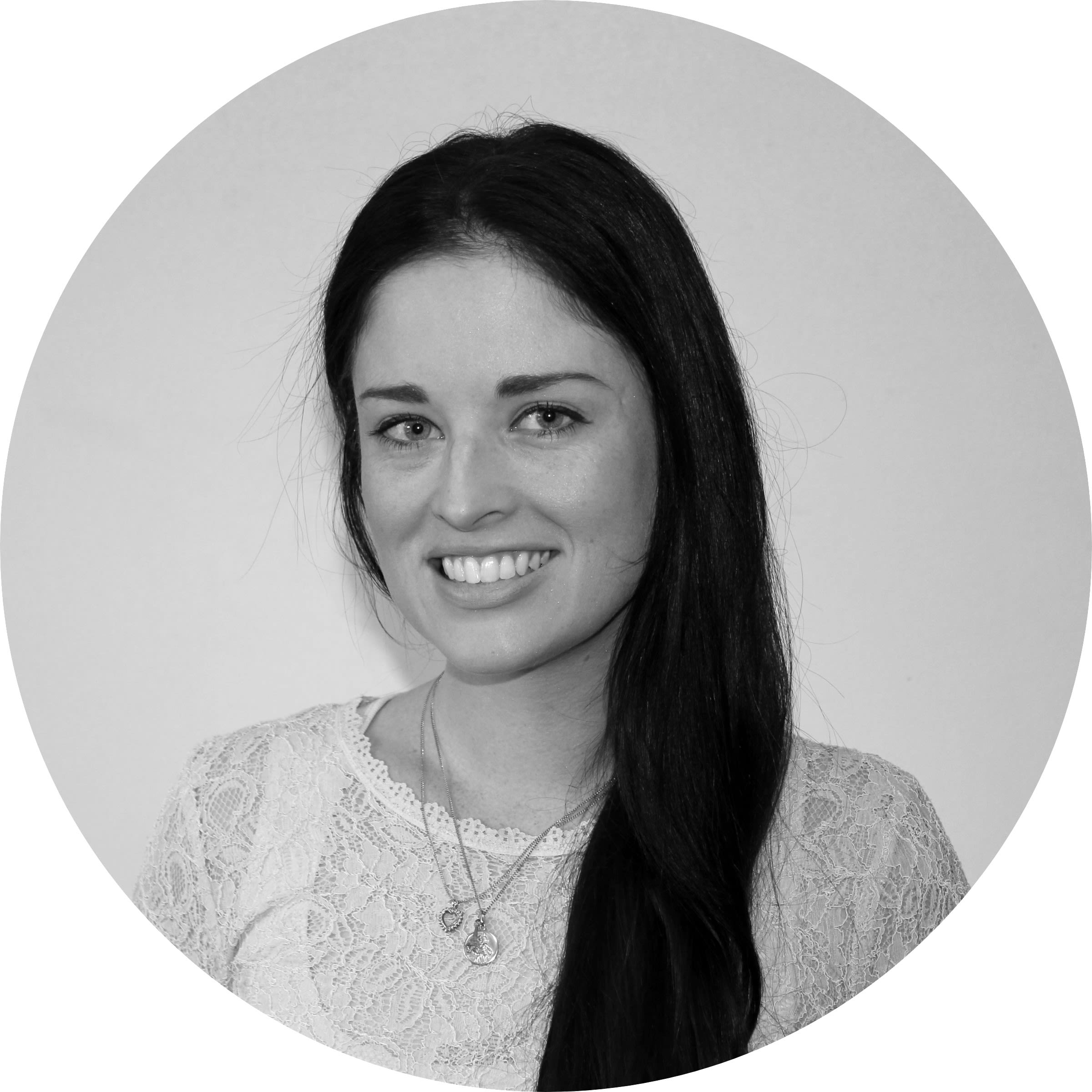 A black-and-white headshot of Megan Gale, a younger women with long dark hair, who is smiling while standing against a plain background