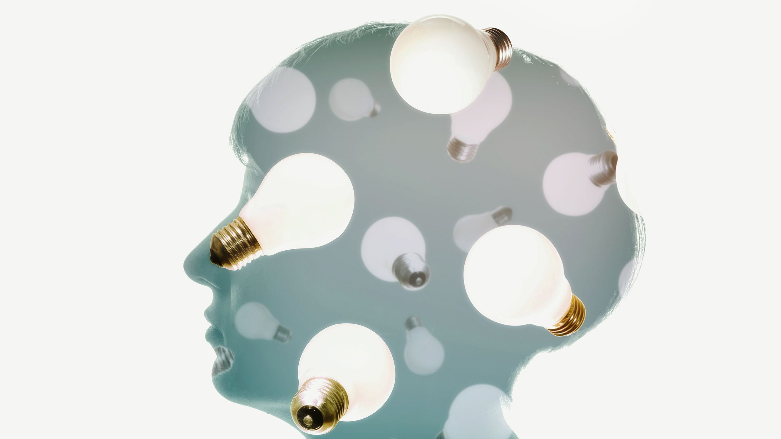 A silhouette of a female head with lightbulbs falling around it.
