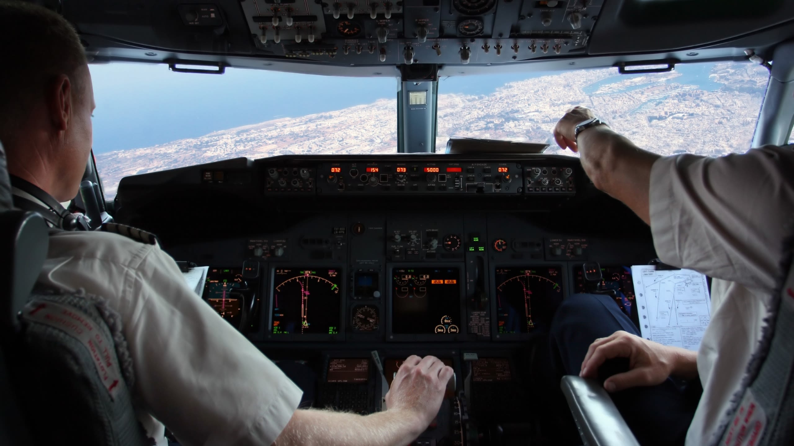 Two pilots flying a plane over a city