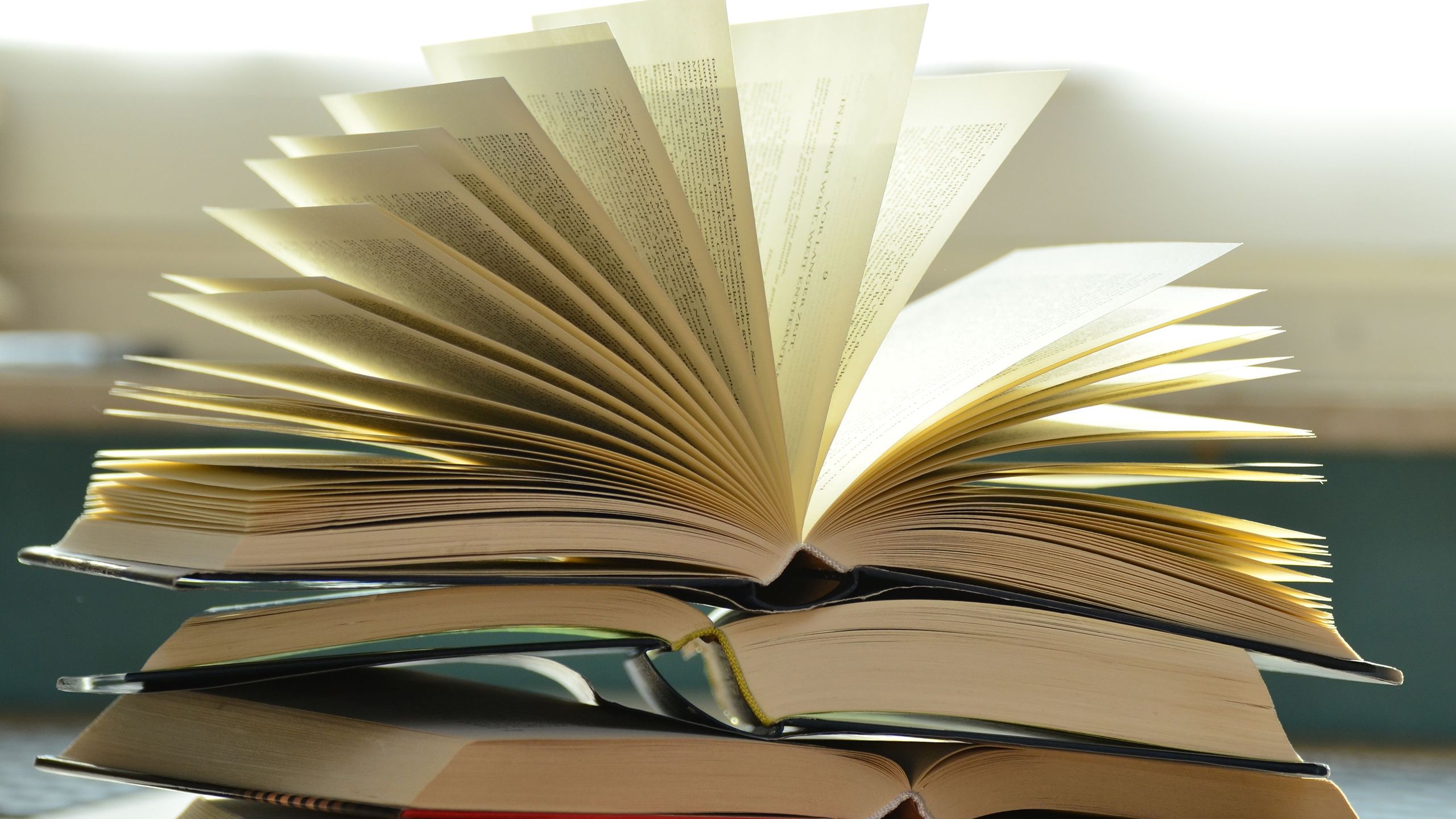 A stack of three open books.